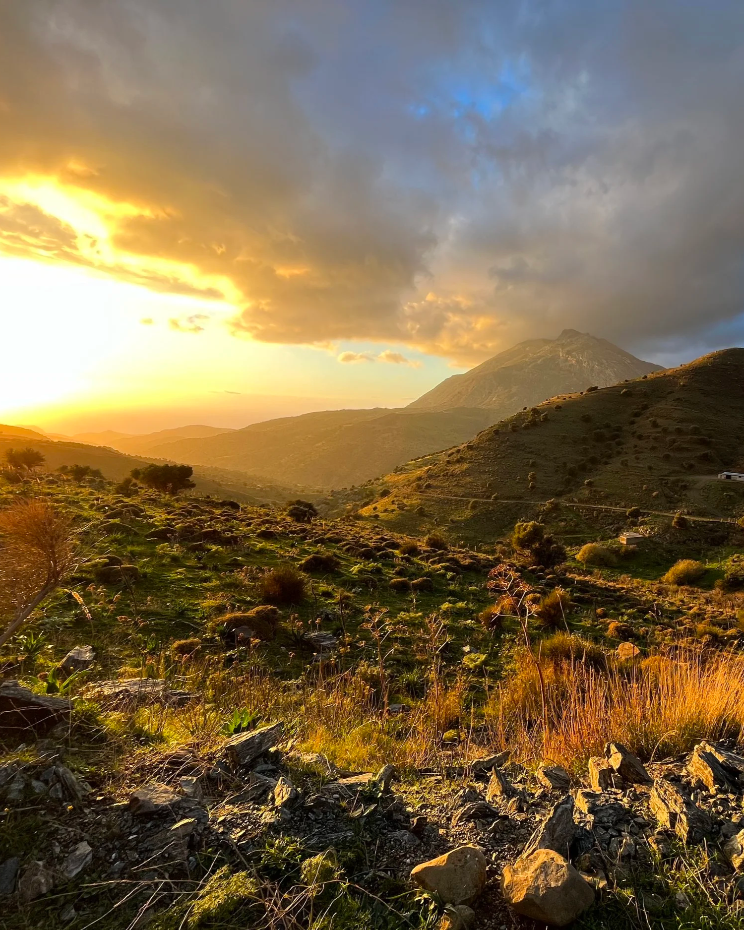 Golden sunset over a valley in South Crete with gentle mountain slopes.