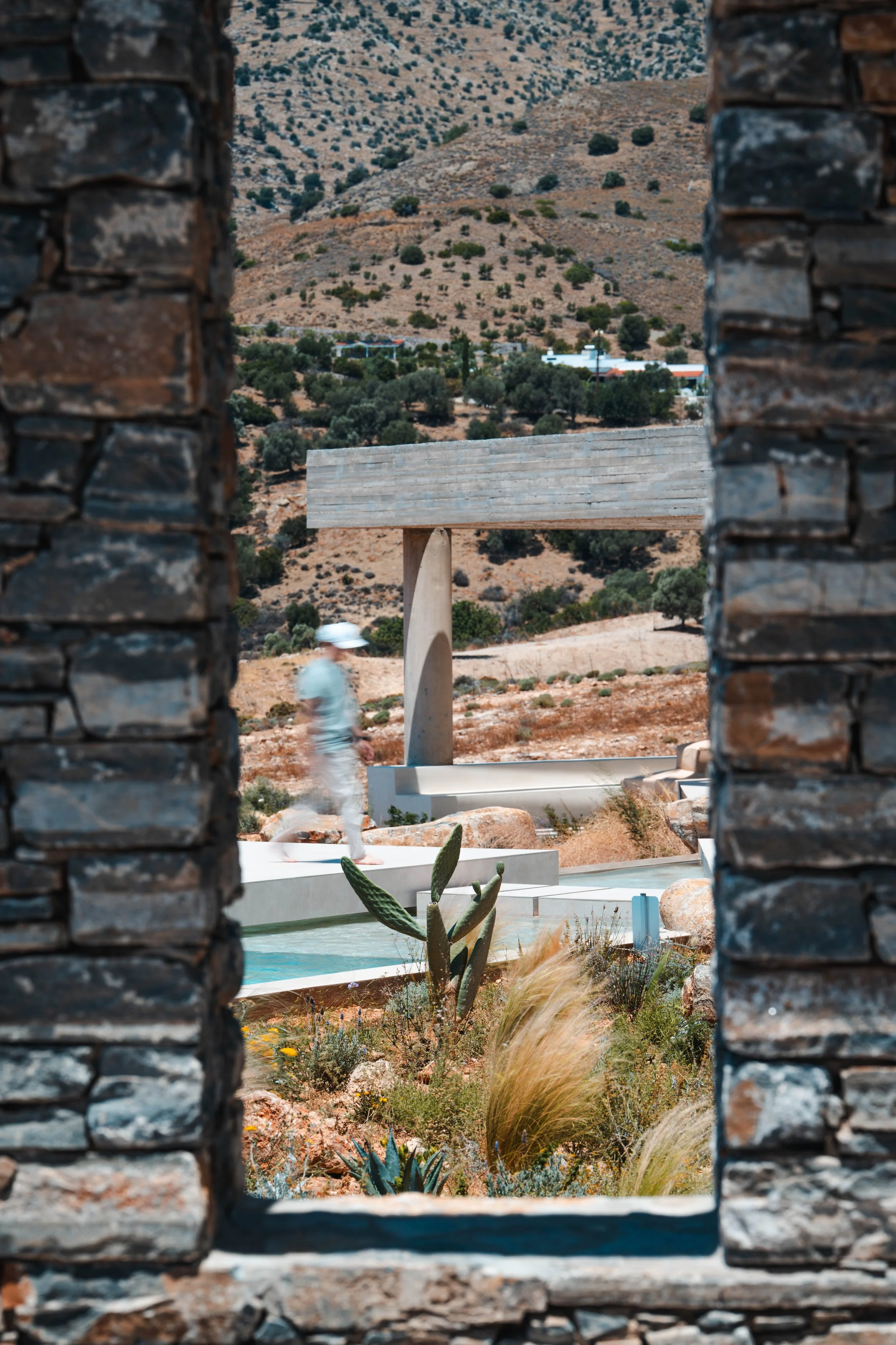 Stone walls framing a private pool with mountain views at a luxury villa in Crete.