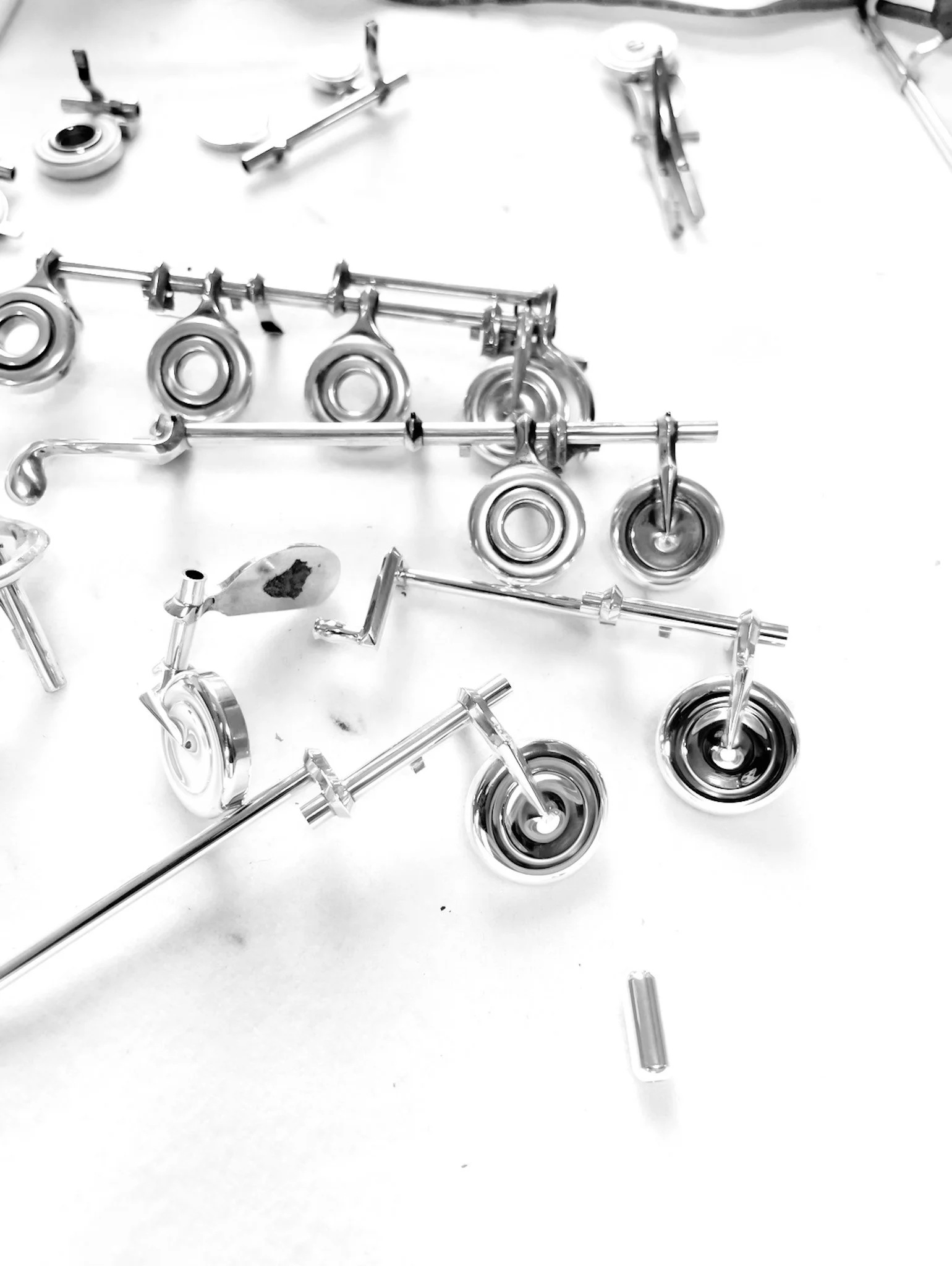 Scattered metallic orthodontic brackets and wires on a white surface.