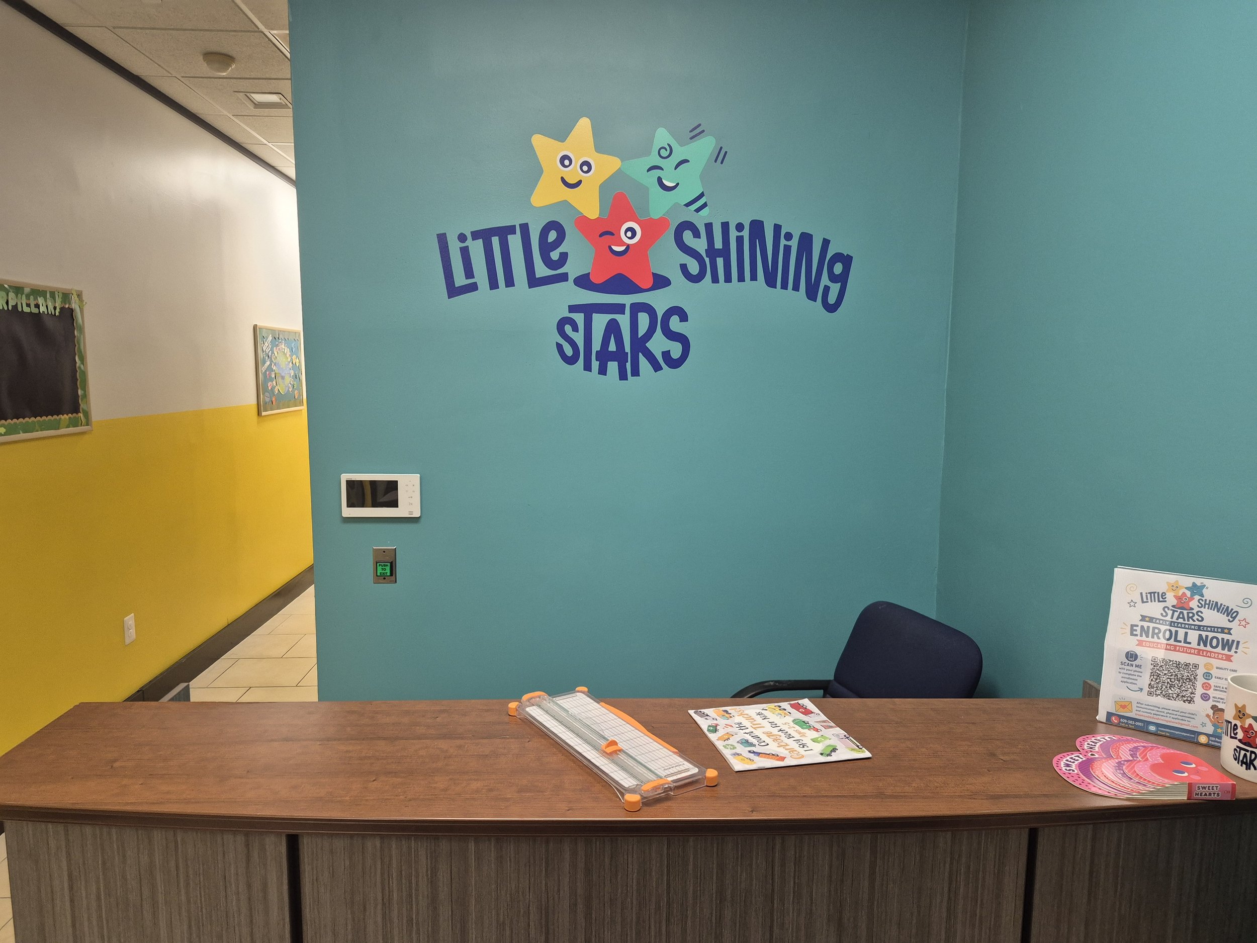 Reception desk and Little Shining Stars logo on a teal wall in our Trenton center.