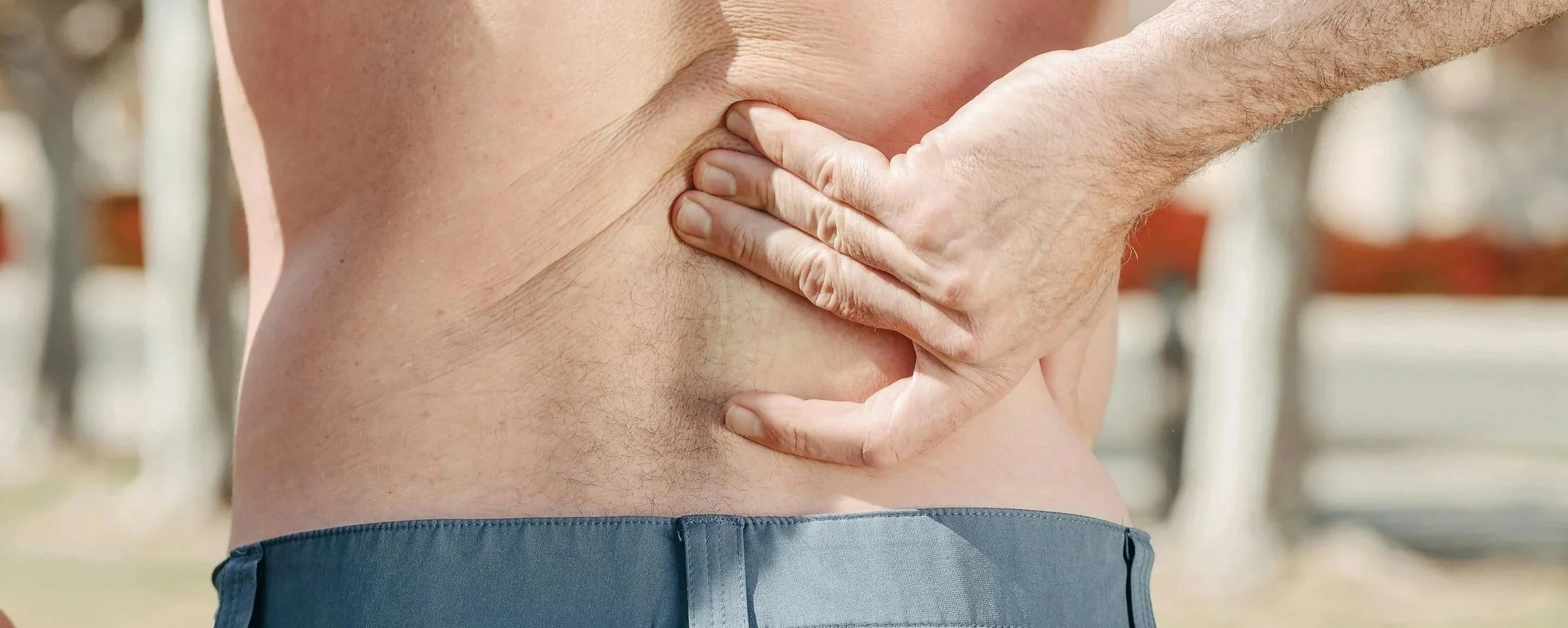 Man Holding Back In Pain  Harry Liniker, Chartered Physiotherapist