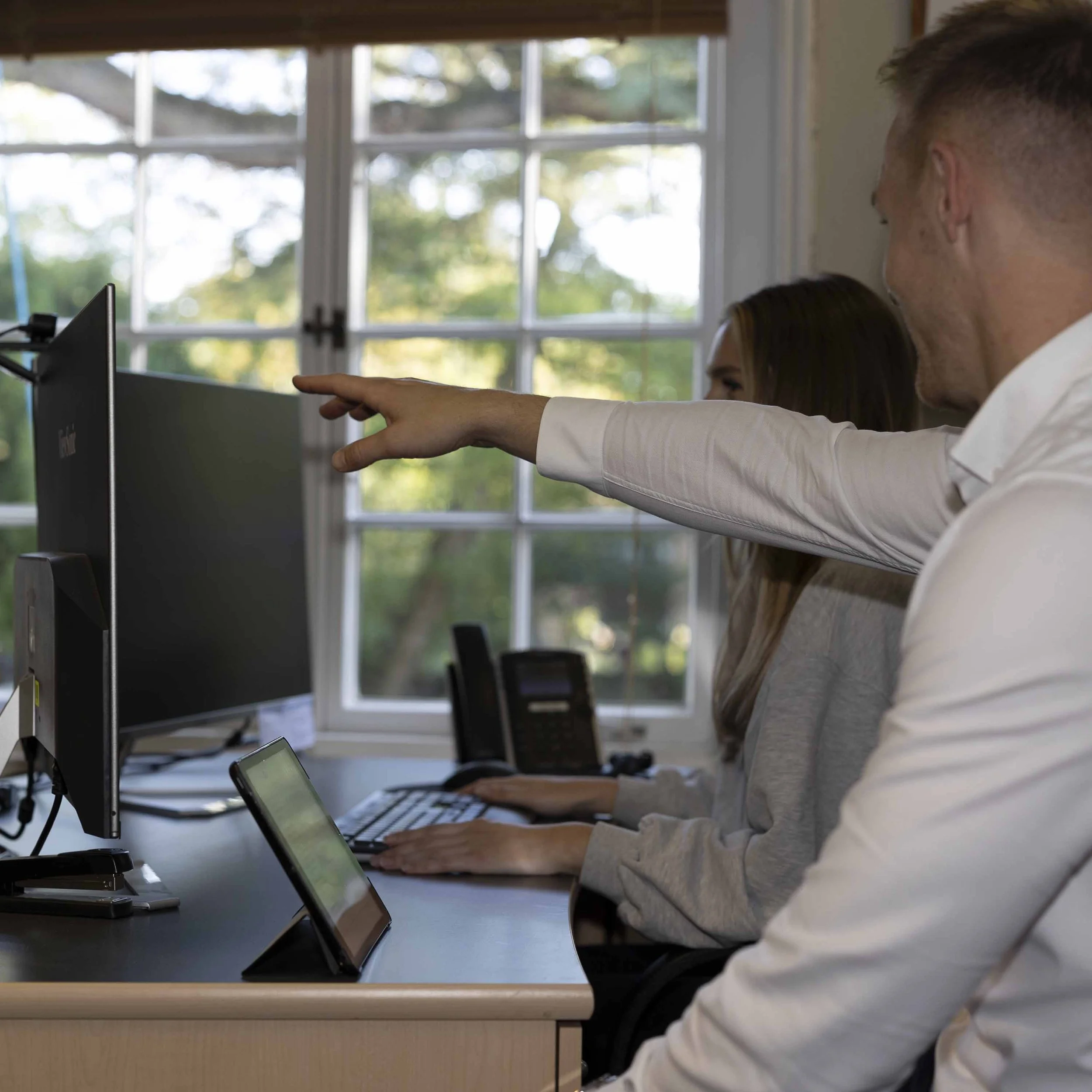A DSE assessor pointing to the correct screen height for an employee