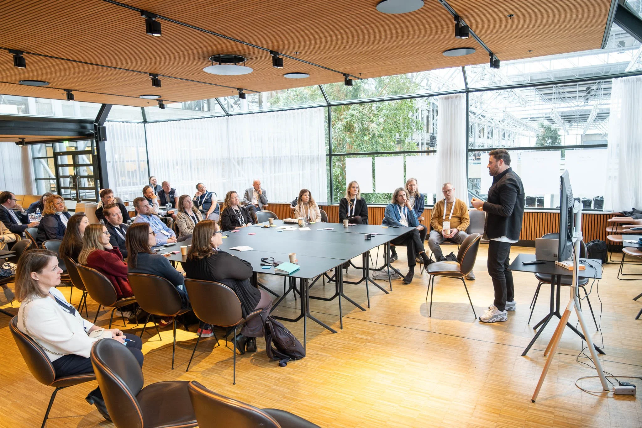 Panel session presenter at screen with seated audience at Illuminate EMEA 2026 — Copenhagen conference photography Ballo Studio