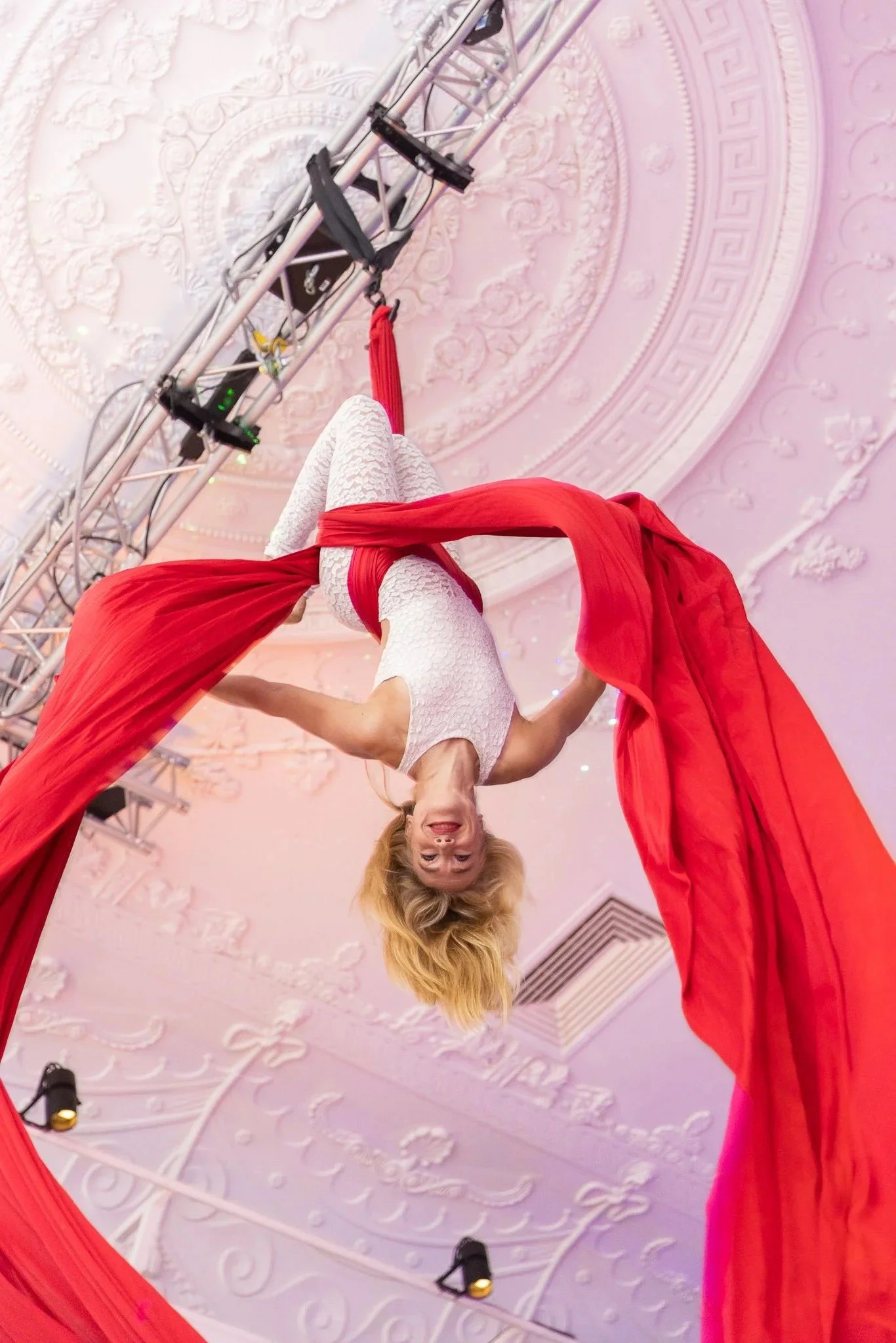 Aerial acrobat performer in white hanging upside down on red silk ribbons at corporate gala event entertainment Amsterdam — gala dinner photography Amsterdam Ballo Studio