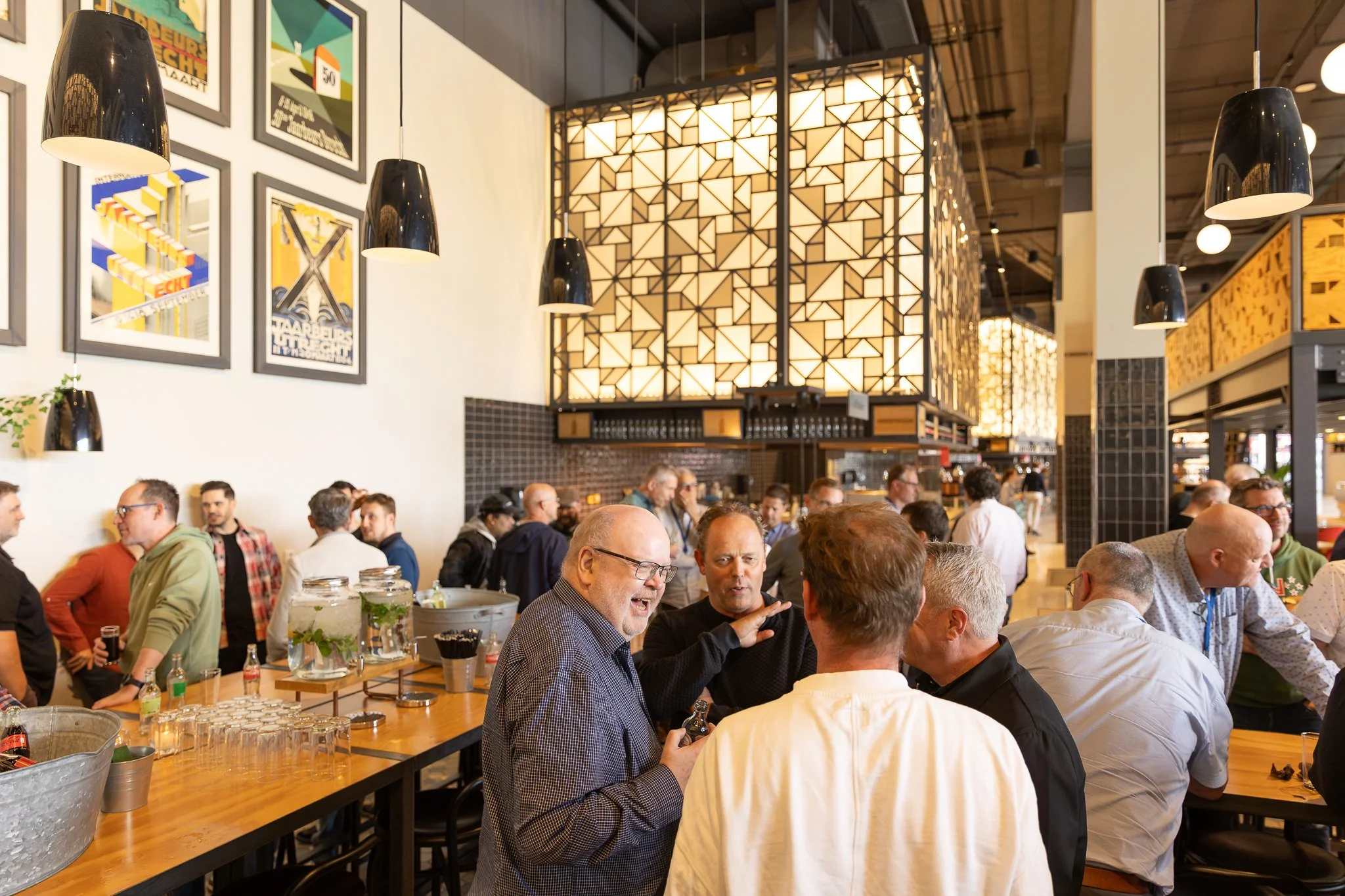 Rabobank colleagues networking in stylish loft venue after QBR, casual atmosphere with art on the walls — internal event photography Amsterdam Ballo Studio