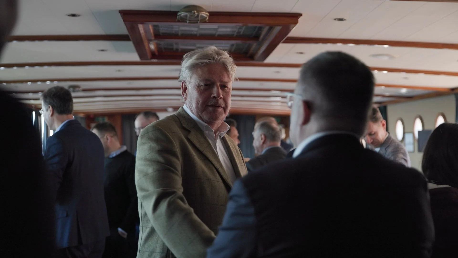 Business delegates networking aboard canal boat during PAIH Polish-Dutch Economic Mission Amsterdam — corporate event photography Amsterdam Ballo Studio