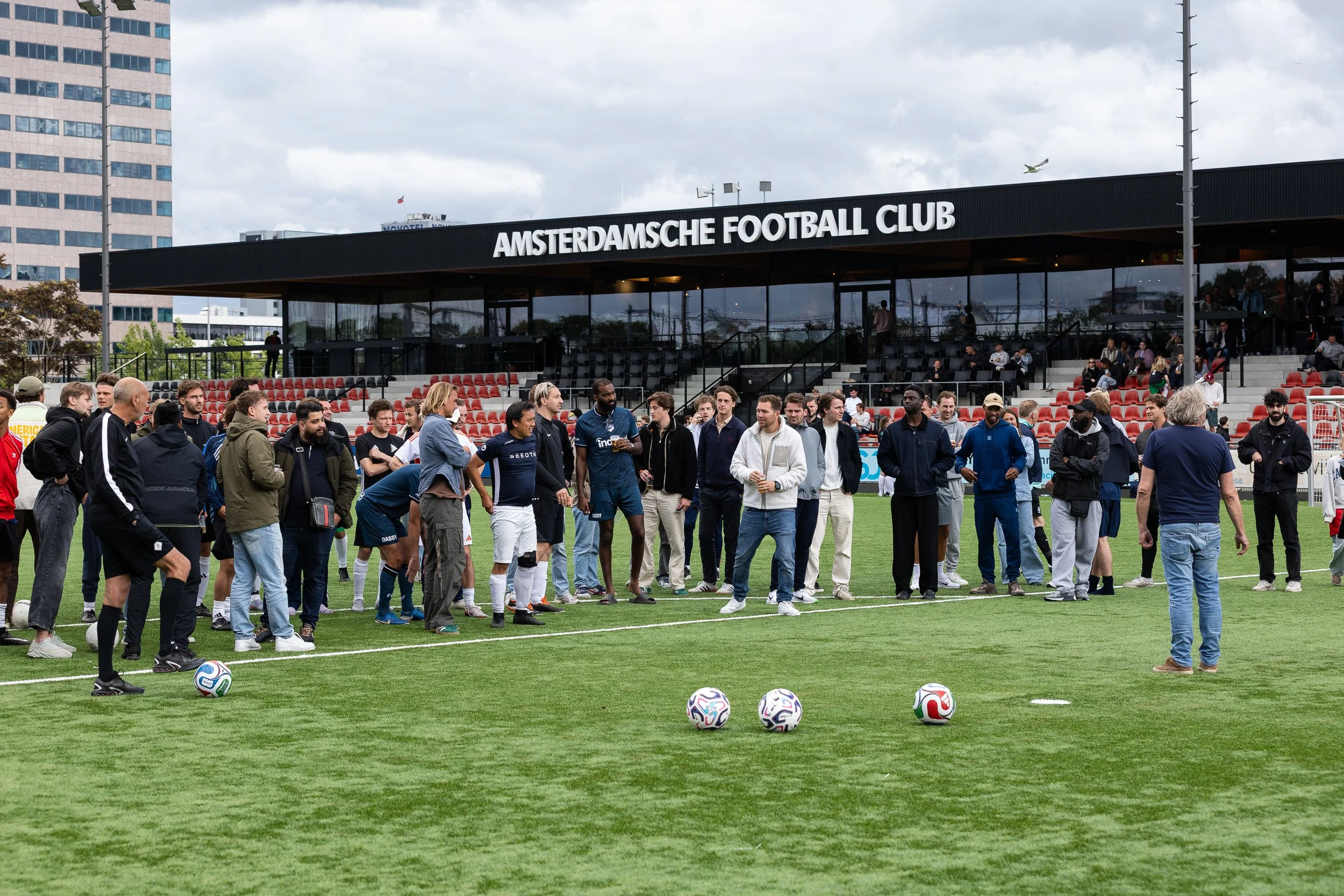 Teams gathering on pitch at Amsterdamsche Football Club for Adfocup 2026 advertising industry tournament — corporate event photography Amsterdam Ballo Studio
