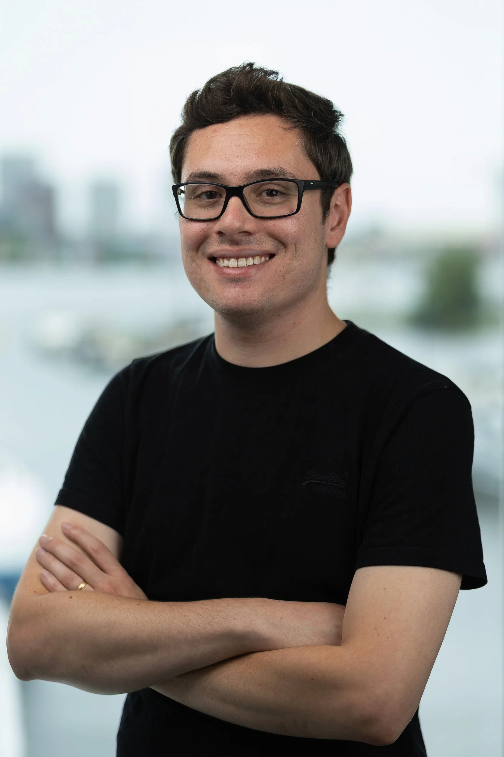 Smiling employee headshot with Amsterdam waterfront background — on-site headshot studio Amsterdam Ballo Studio