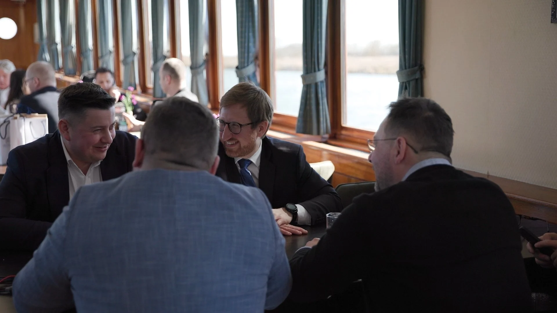 Polish and Dutch business delegates in discussion at waterside dinner during PAIH Economic Mission — conference photography Amsterdam Ballo Studio