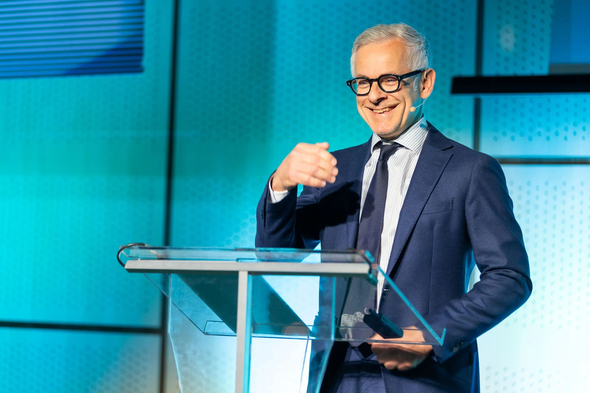 Male keynote speaker at glass podium during plenary session at Euroheat & Power Congress Amsterdam — conference photographer Ballo Studio