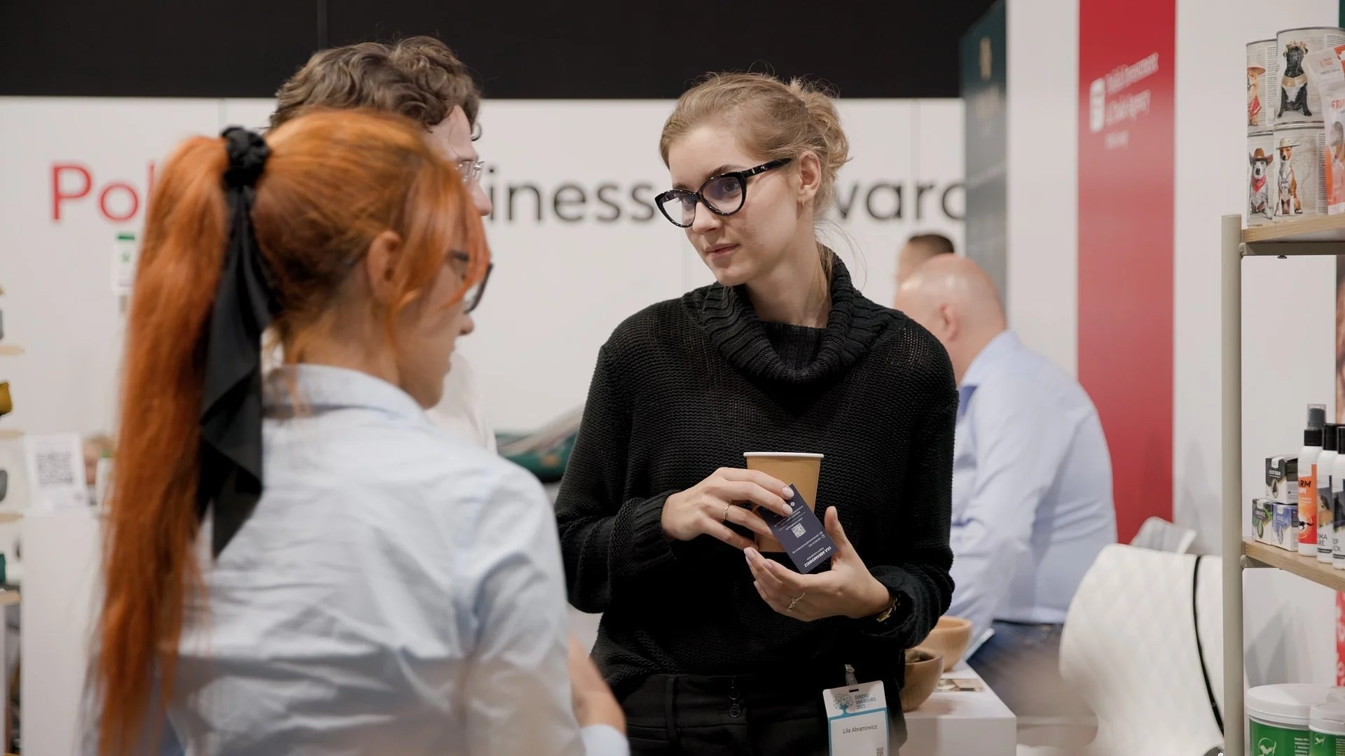 Attendees in conversation at Poland Business Forward exhibition stand during PAIH trade mission — corporate event photography Amsterdam Ballo Studio