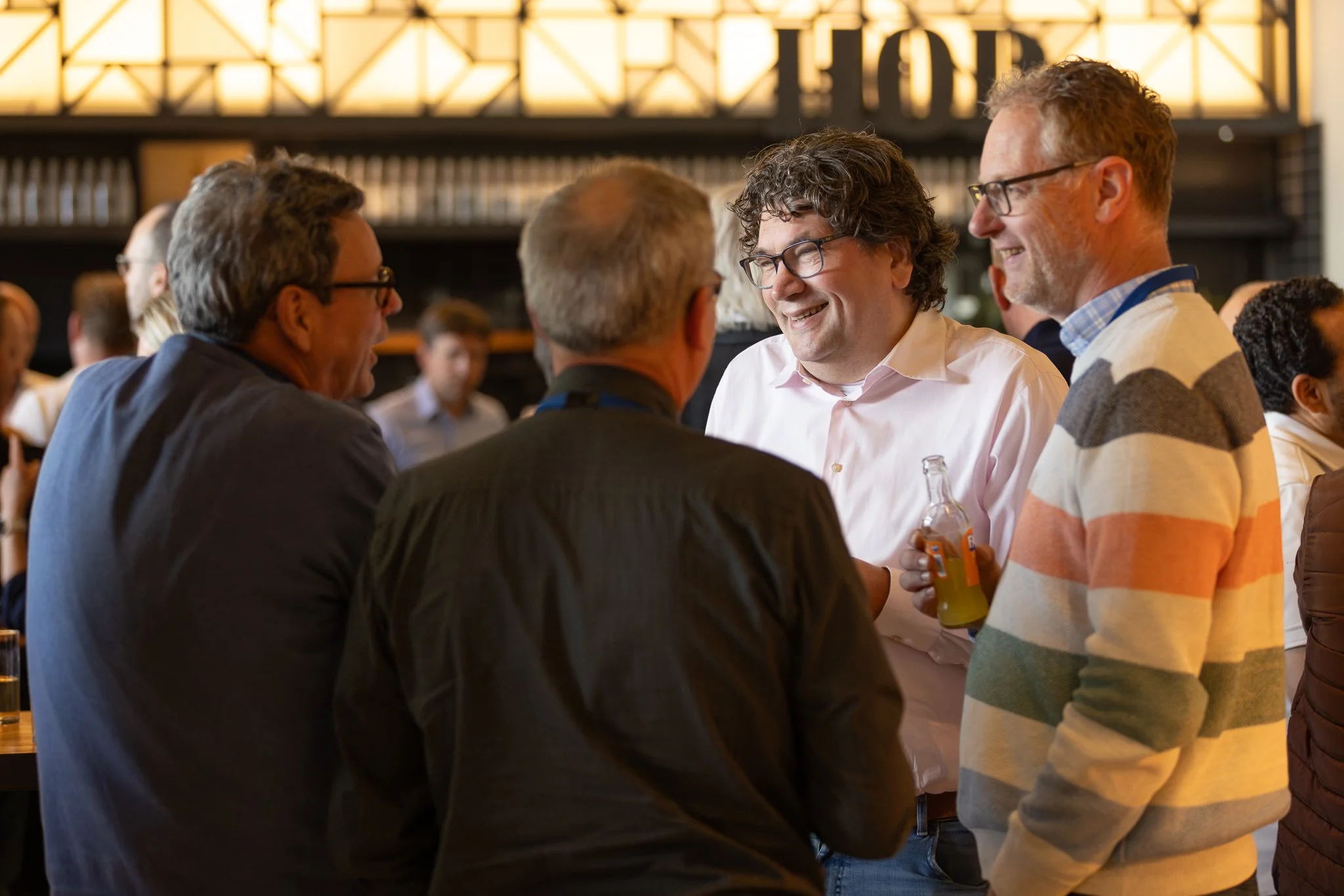 Rabobank employee smiling warmly during networking at QBR social event — corporate event photography Amsterdam Ballo Studio