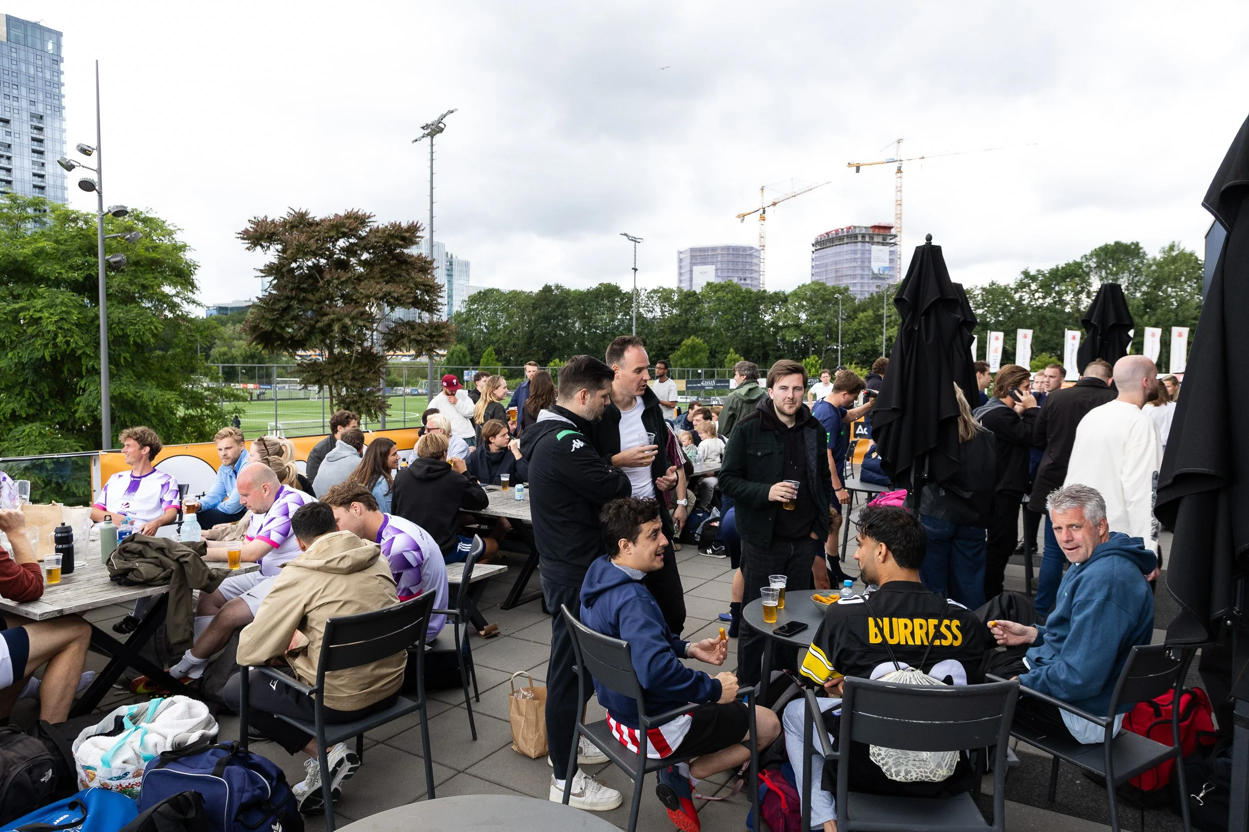 Players and spectators relaxing on busy outdoor terrace between matches at Adfocup 2026 Amsterdam — event photography Amsterdam Ballo Studio