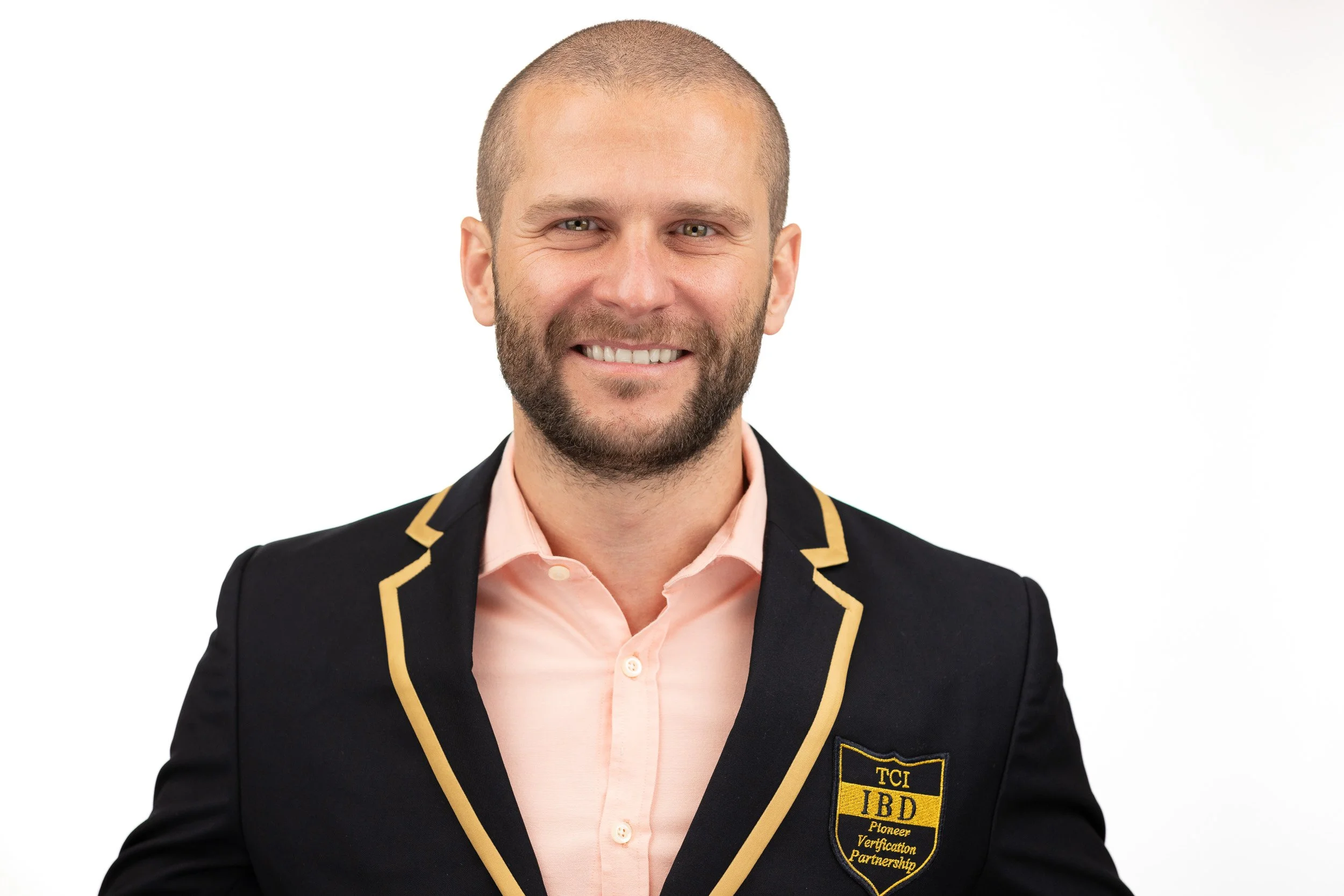TCI Biotech employee headshot, smiling man in branded TCI IBD blazer with gold trim — corporate headshot photographer Amsterdam Ballo Studio