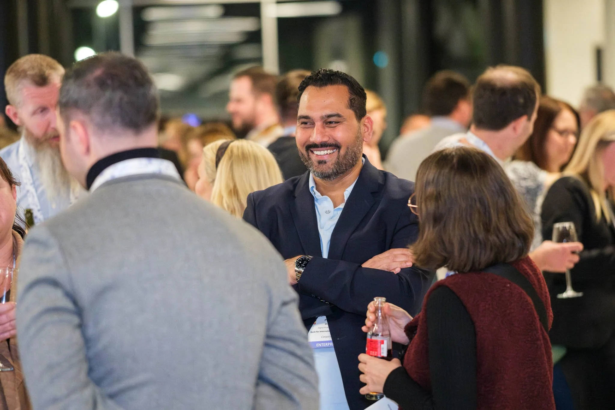 Delegate smiling and networking at Illuminate EMEA 2026 drinks reception — Copenhagen event photography Ballo Studio