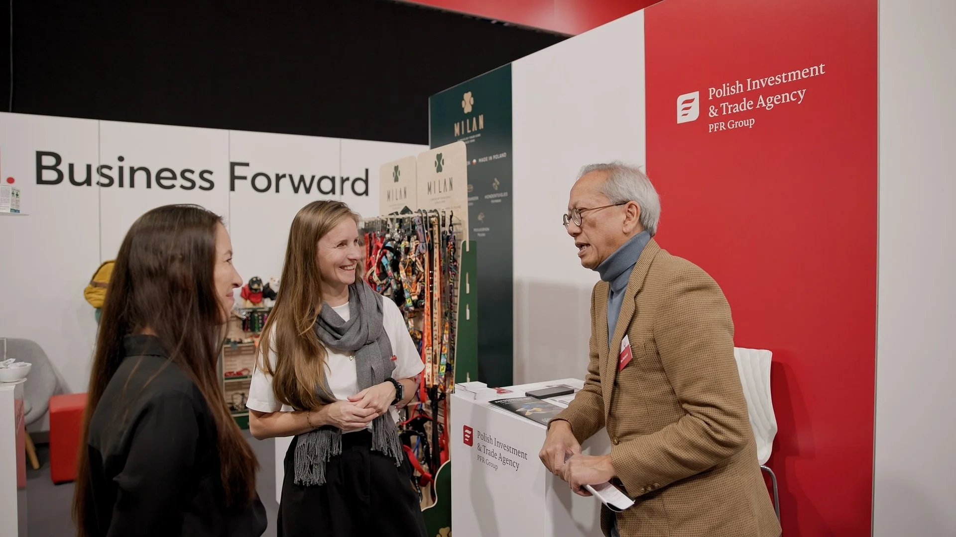 PAIH Polish Investment and Trade Agency representatives welcoming visitor at Business Forward exhibition stand — event photography Amsterdam Ballo Studio
