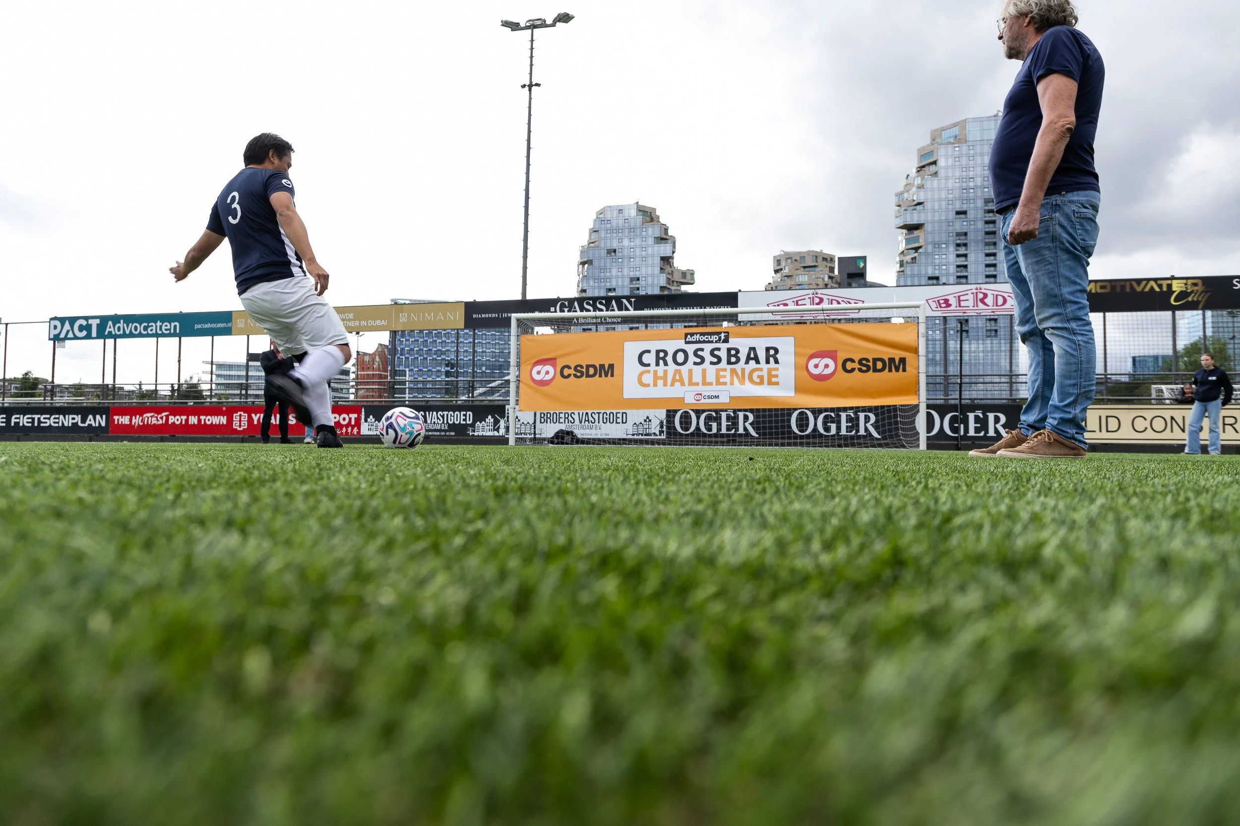 Player number 3 taking a penalty shot during CSDM Crossbar Challenge at Adfocup 2026 corporate football tournament Amsterdam — event photography Amsterdam Ballo Studio