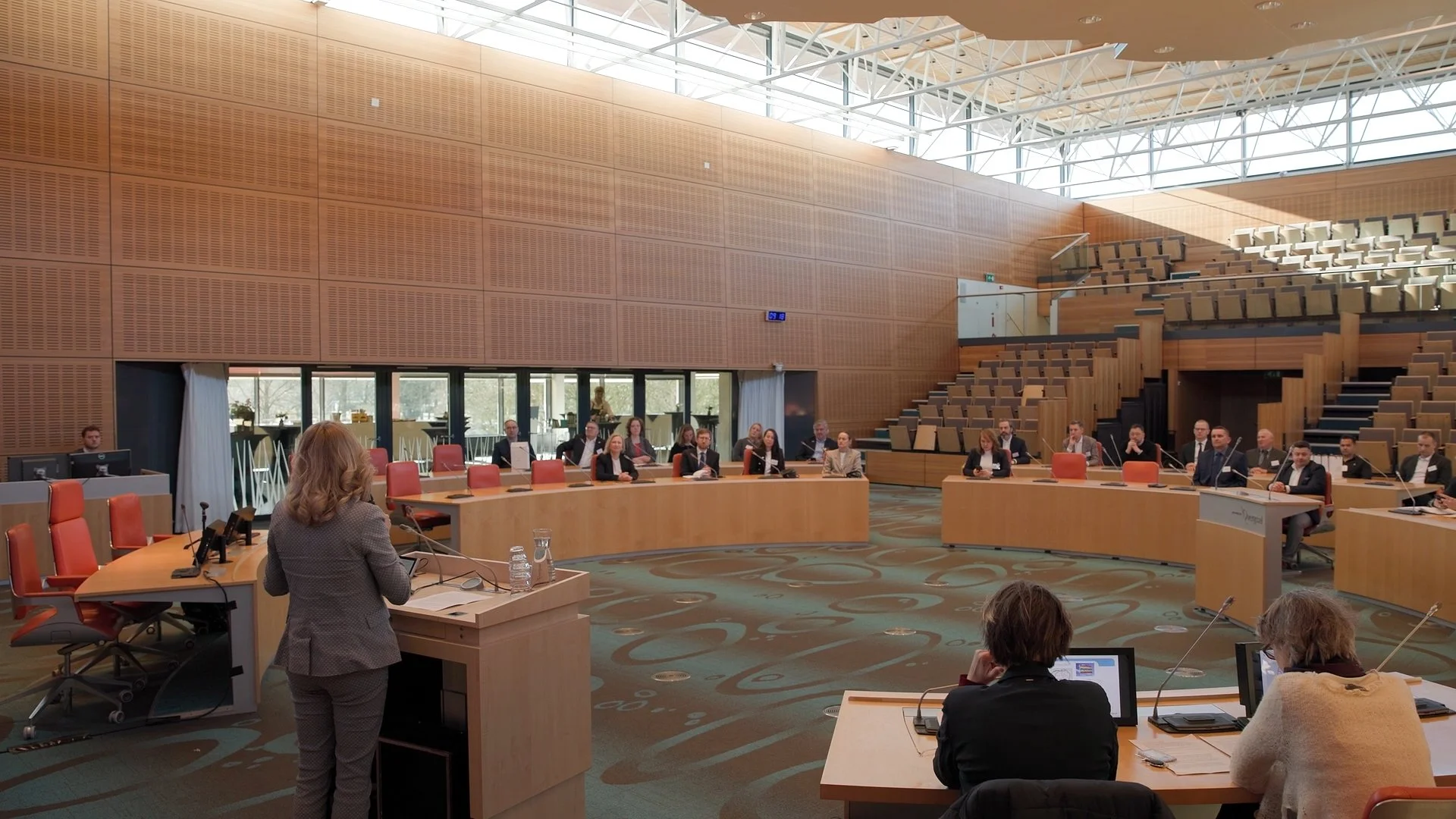 Female speaker addressing delegates in parliament chamber at PAIH Polish-Dutch Economic Mission — conference photography Amsterdam Ballo Studio