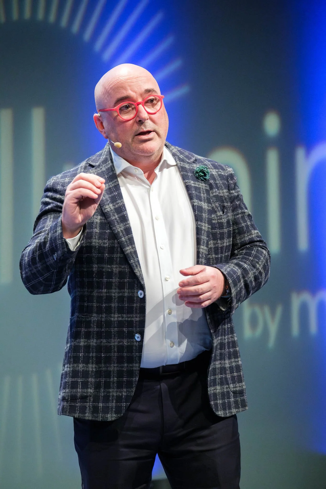 Keynote speaker in checked blazer presenting at Illuminate EMEA 2026 — Copenhagen conference event photography Ballo Studio