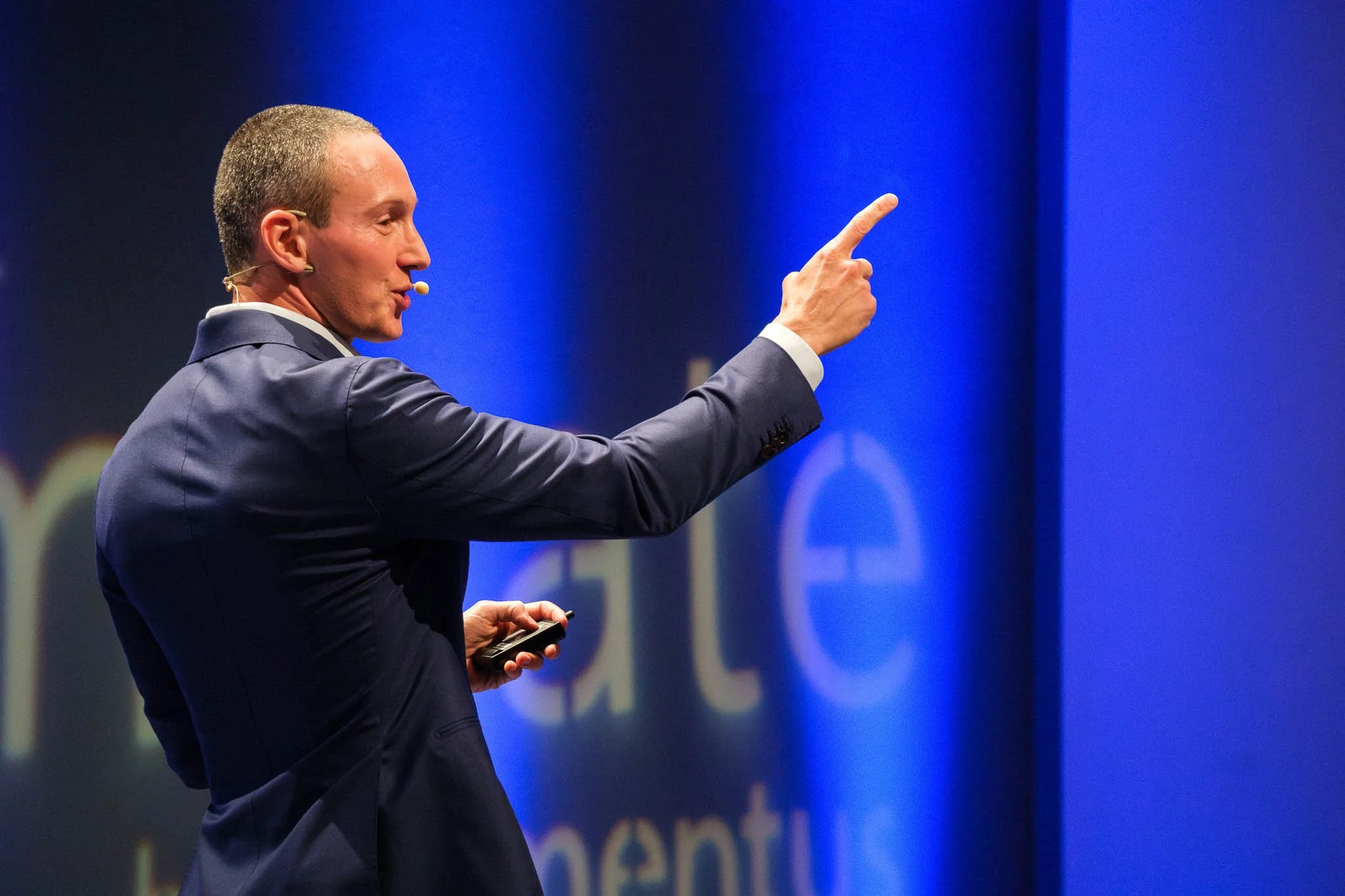 Keynote speaker pointing to audience on stage at Illuminate EMEA 2026 — Copenhagen conference photography by Ballo Studio