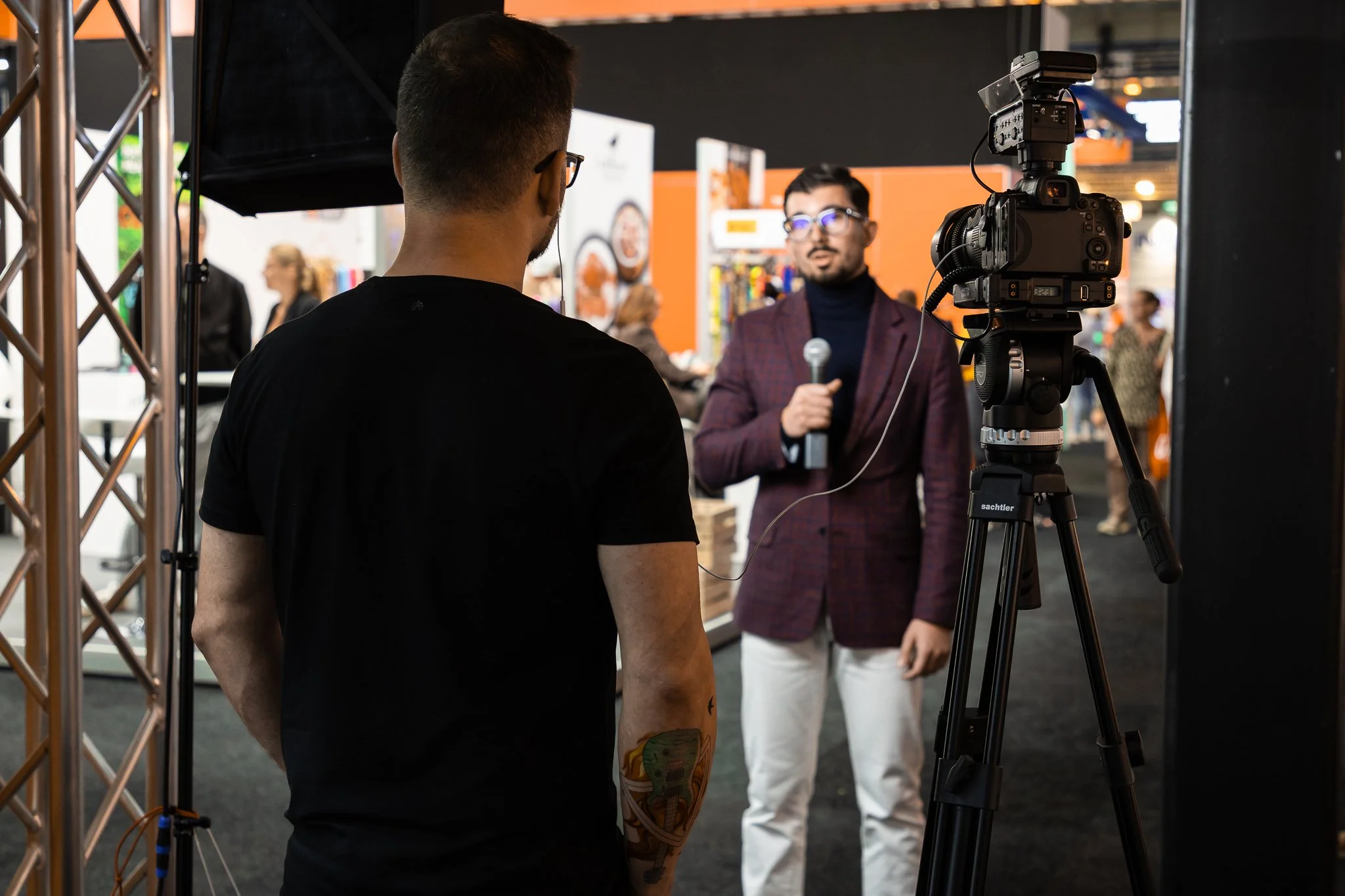 Behind-the-scenes event video production at a corporate conference in Amsterdam, filming an on-site interview with professional camera and lighting setup.