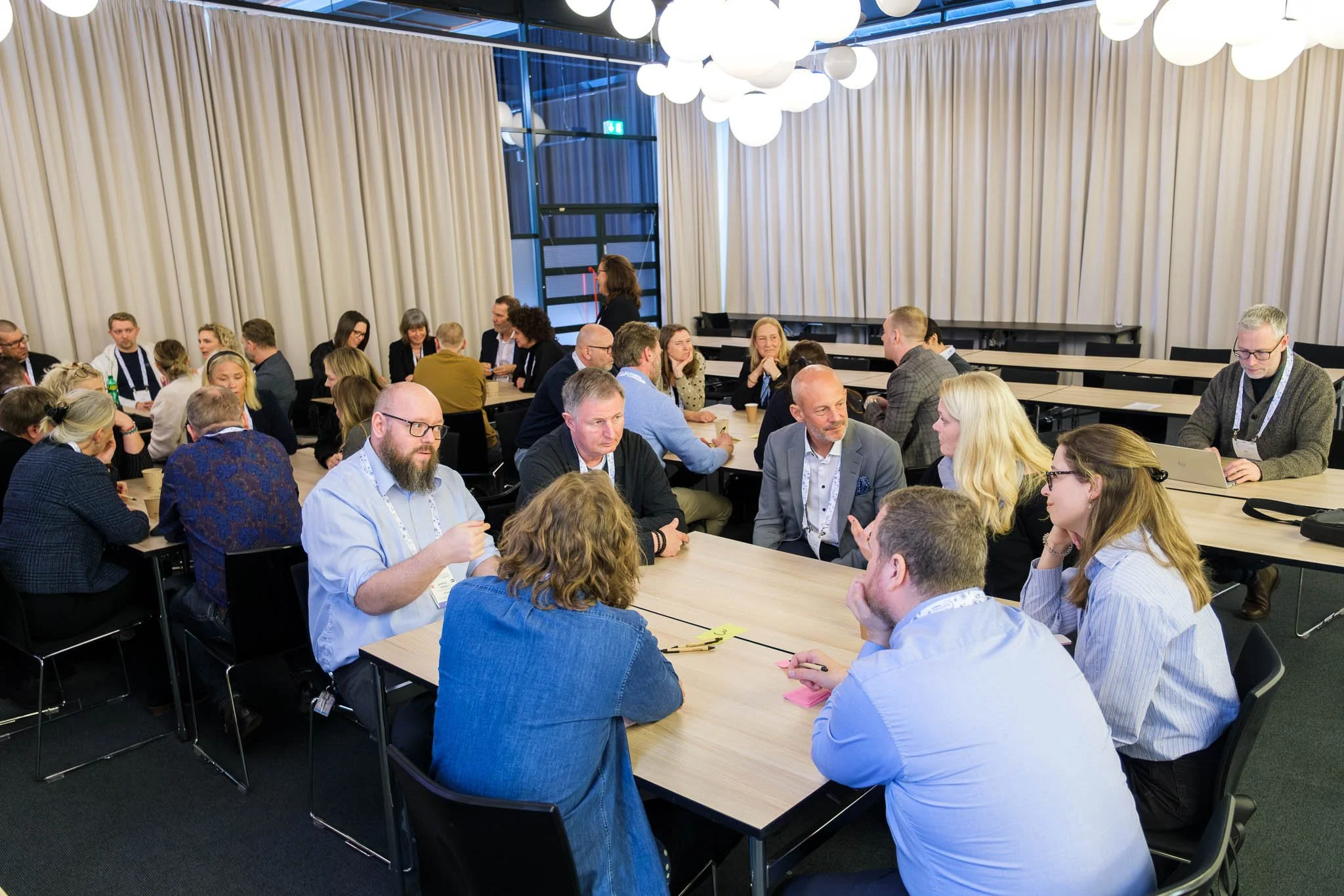 Delegates in roundtable workshop discussion at Illuminate EMEA 2026 — Copenhagen conference photography Ballo Studio