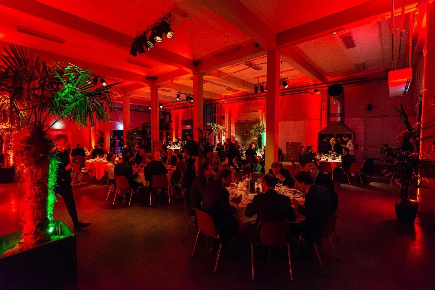 Gala dinner with red event lighting and tropical decor at corporate celebration Amsterdam — gala dinner photography Amsterdam Ballo Studio