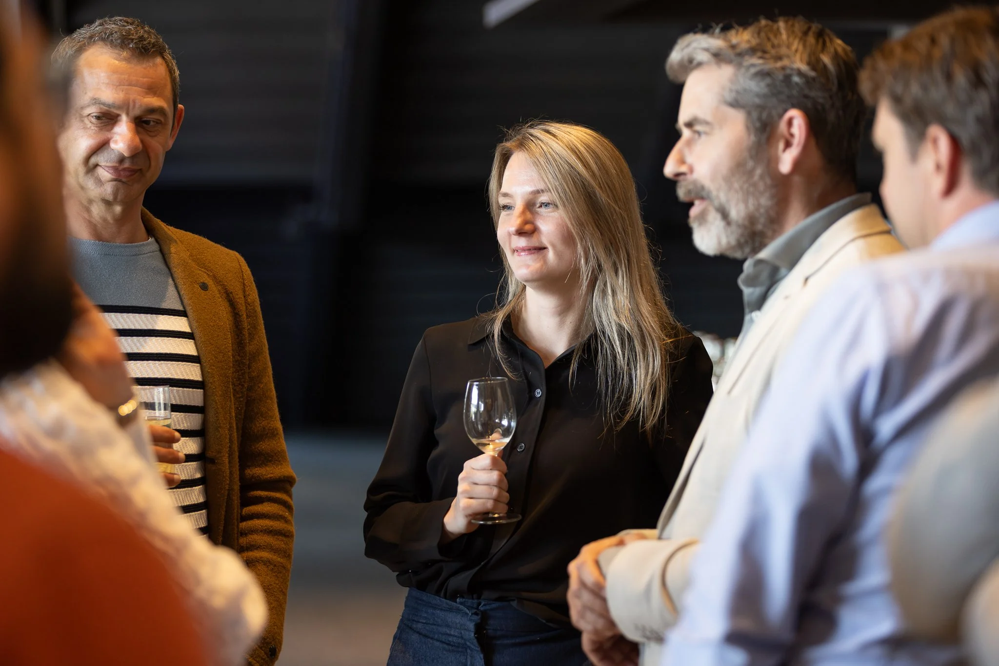 Rabobank employees networking at QBR reception, woman holding wine glass — corporate event photography Amsterdam Ballo Studio