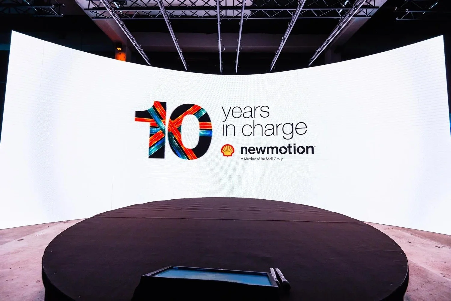 NewMotion 10 Years in Charge event stage with large LED screen at corporate anniversary celebration — event photography Amsterdam Ballo Studio