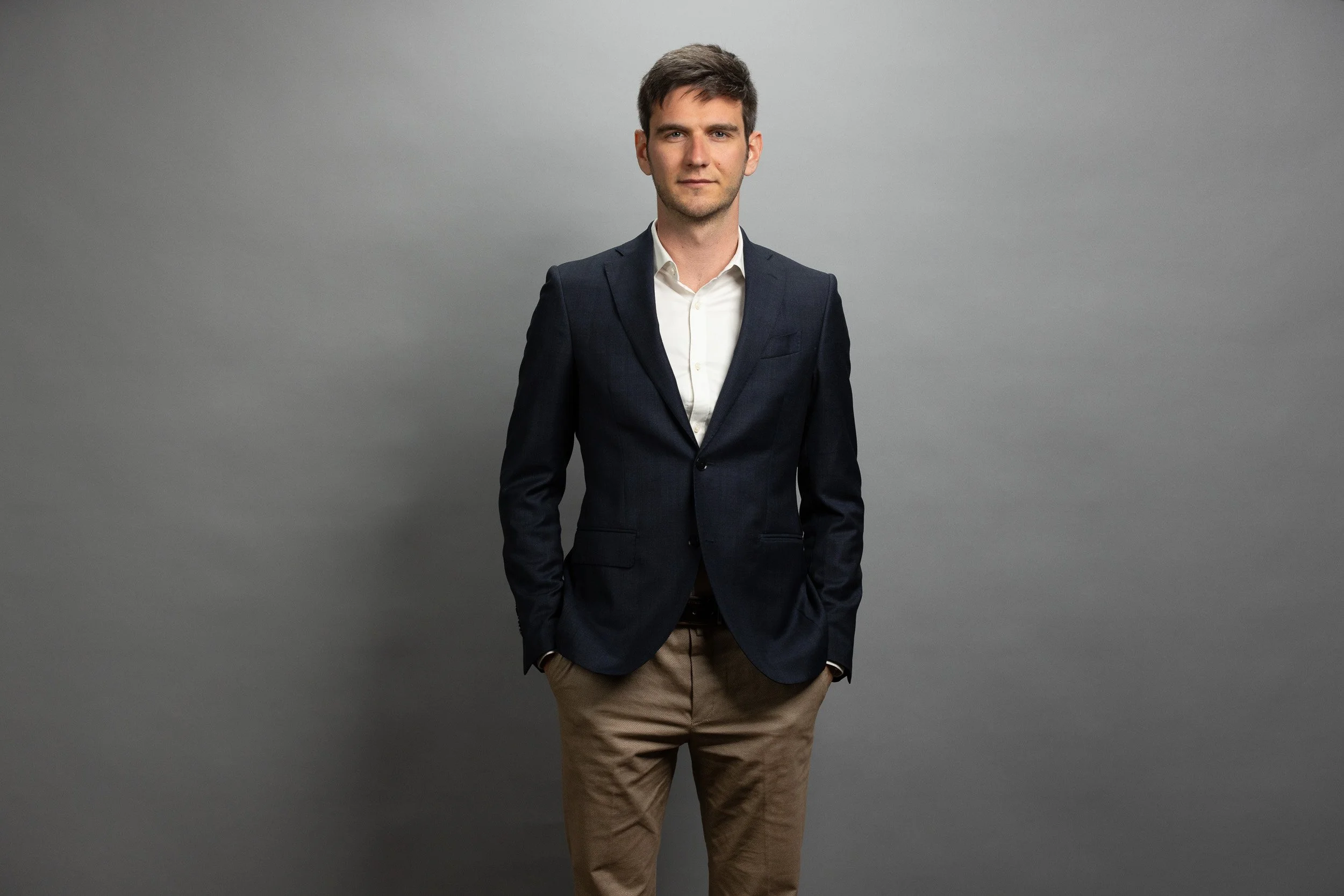 EPEX SPOT employee portrait, smiling man in black shirt with arms crossed — corporate headshot photographer Amsterdam Ballo Studio