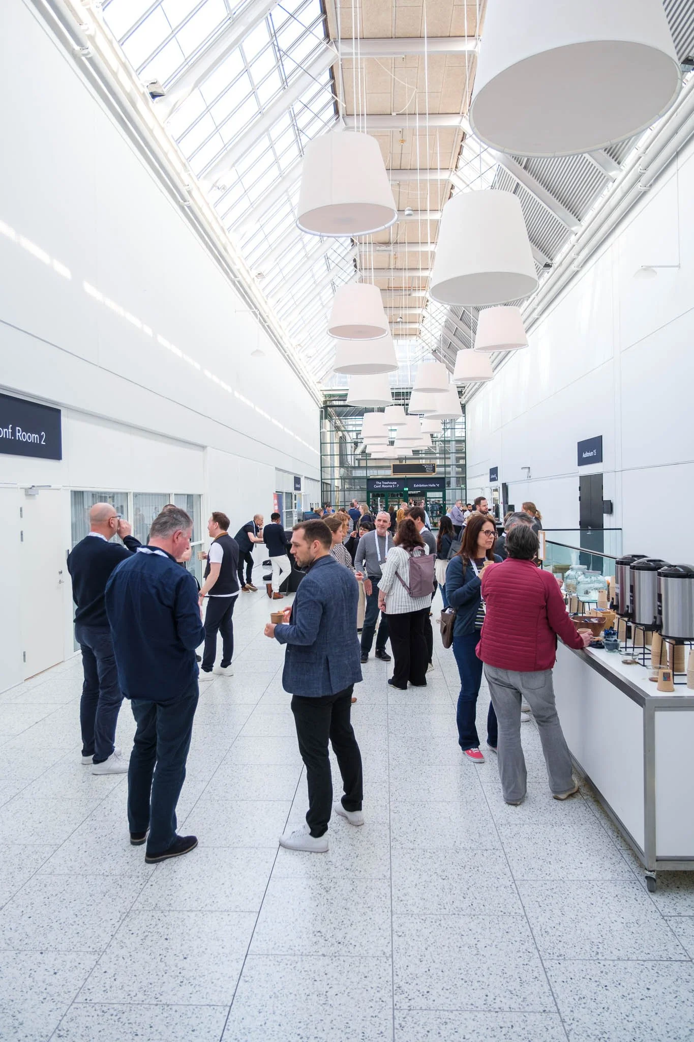 Attendees mingling in venue corridor during coffee break at Illuminate EMEA 2026 — Copenhagen event photography Ballo Studio