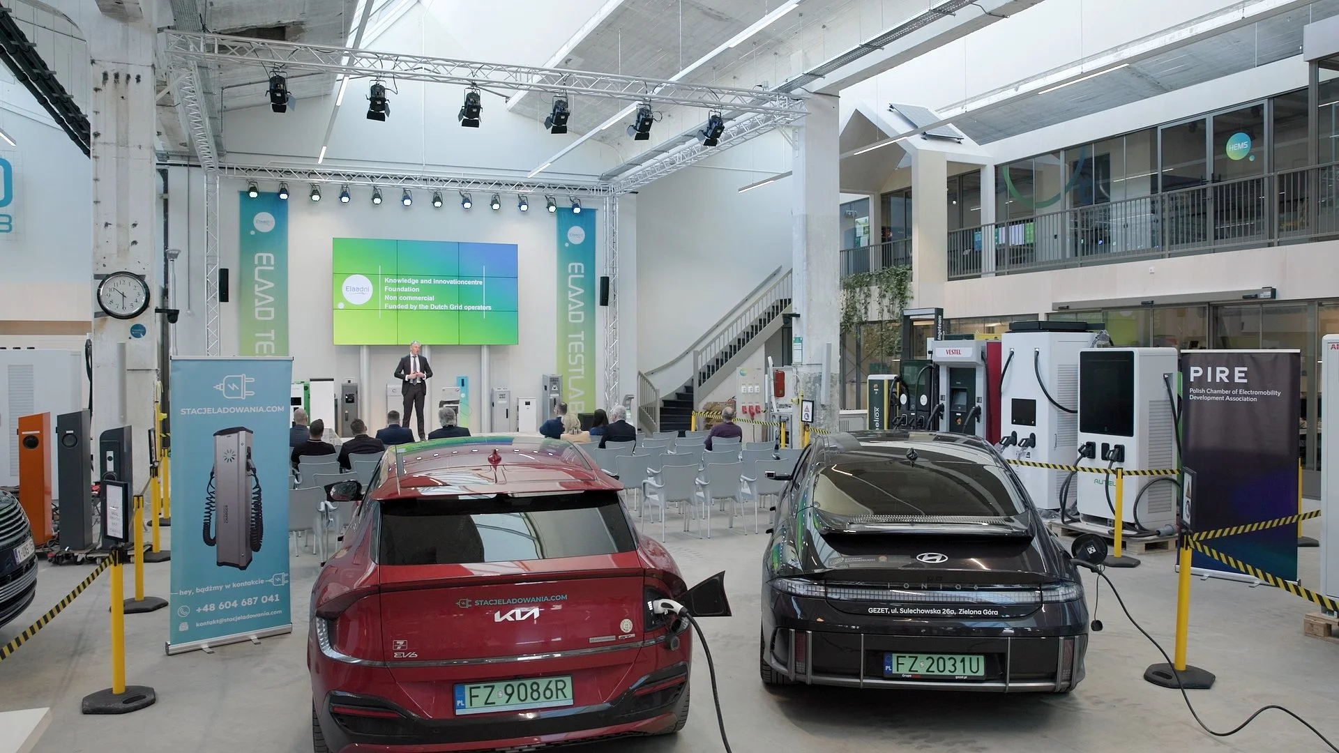 Trade show floor with electric vehicles and EV charging stations at PAIH Polish-Dutch Economic Mission — event photography Amsterdam Ballo Studio