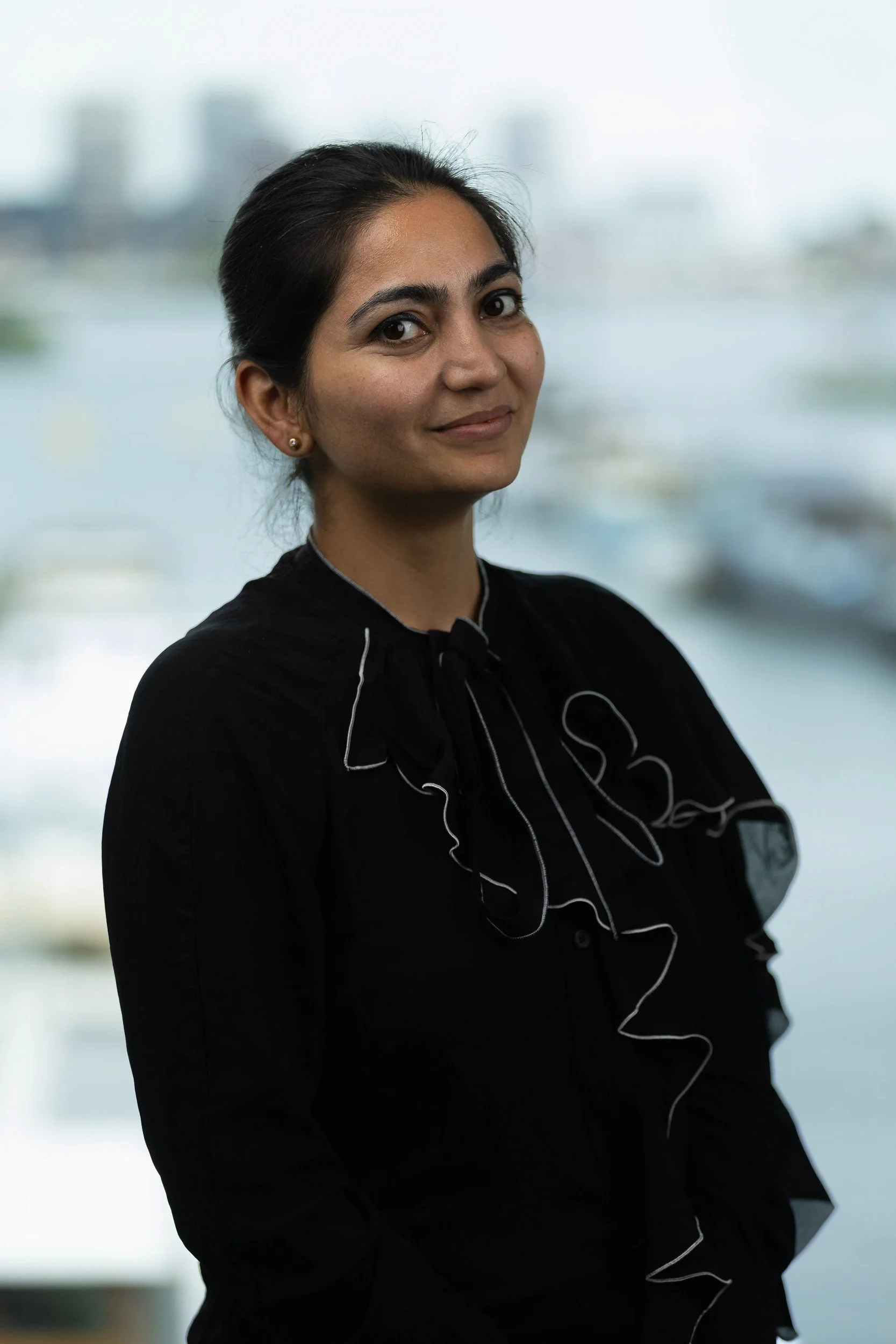 Employee headshot of woman in black top with Amsterdam canal and boats background — employee headshots Amsterdam Ballo Studio