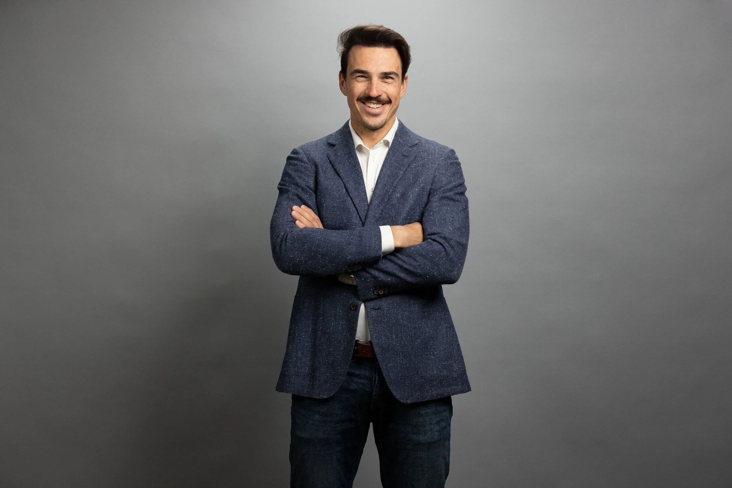 EPEX SPOT employee portrait, young man in navy blazer and khaki trousers, hands in pockets — employee headshots Amsterdam Ballo Studio