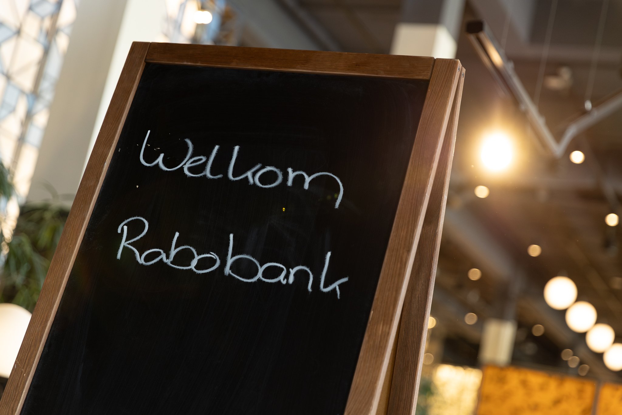 Rabobank QBR networking reception with large crowd of employees in industrial loft venue with art gallery wall — corporate photographer Amsterdam Ballo Studio