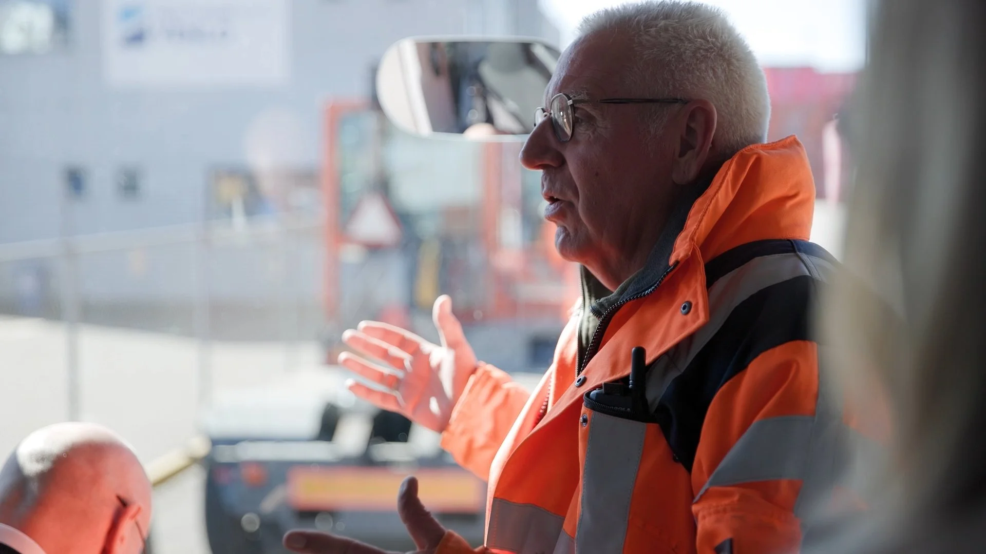 Port guide in orange high-vis jacket explaining harbour operations during PAIH Polish-Dutch Economic Mission — corporate event photography Amsterdam Ballo Studio