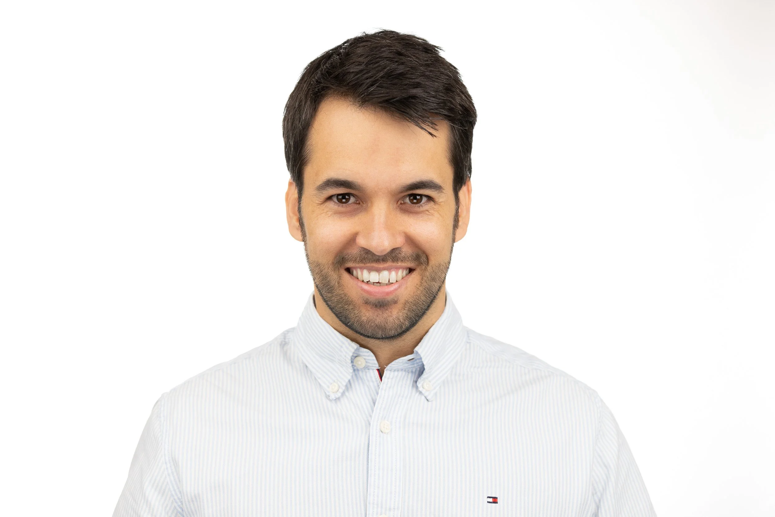 TCI Biotech employee headshot, smiling man in light blue shirt, white background studio portrait — business portrait photography Amsterdam Ballo Studio