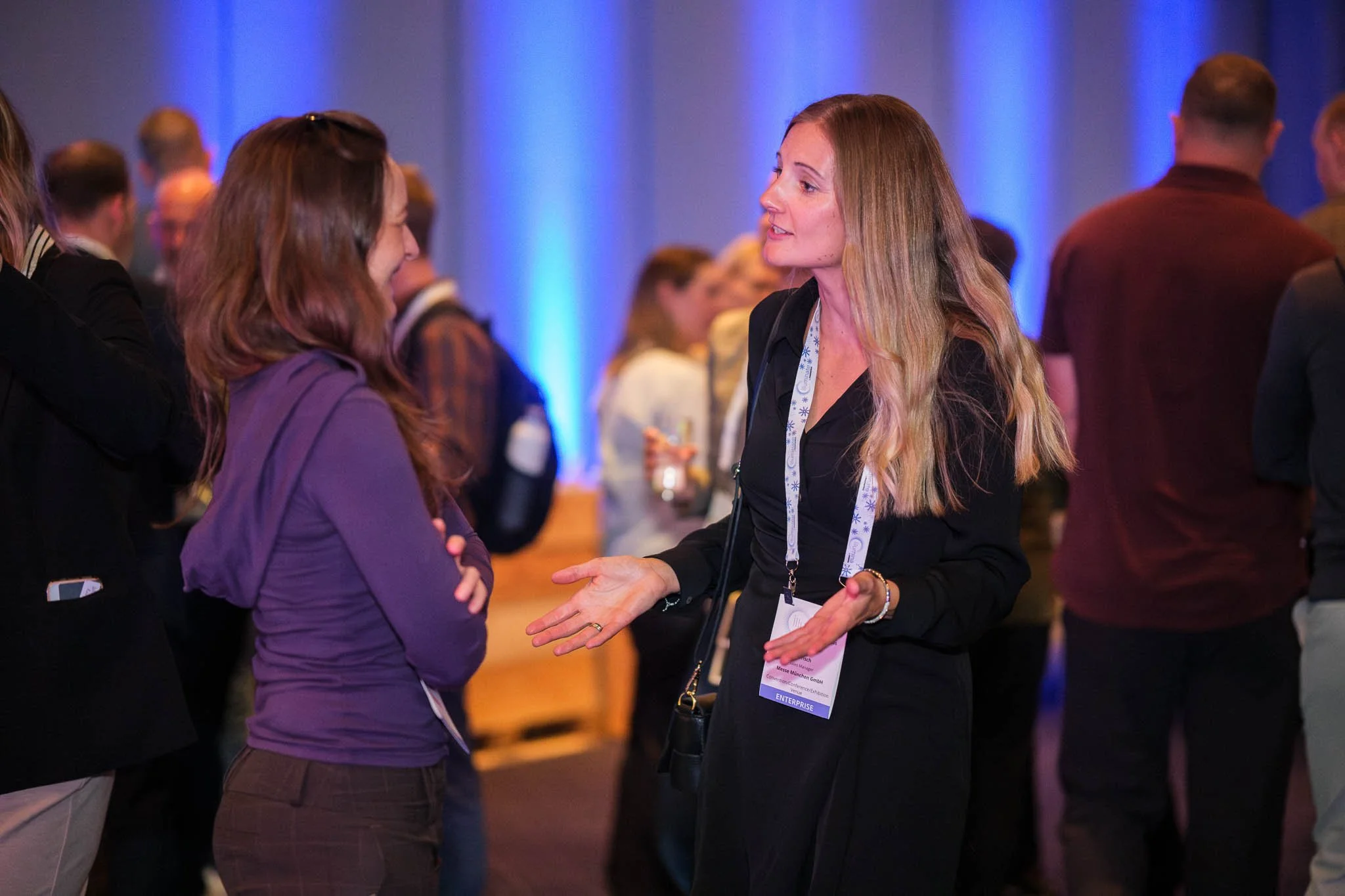 Two attendees in conversation at Illuminate EMEA 2026 reception — Copenhagen event photography Ballo Studio