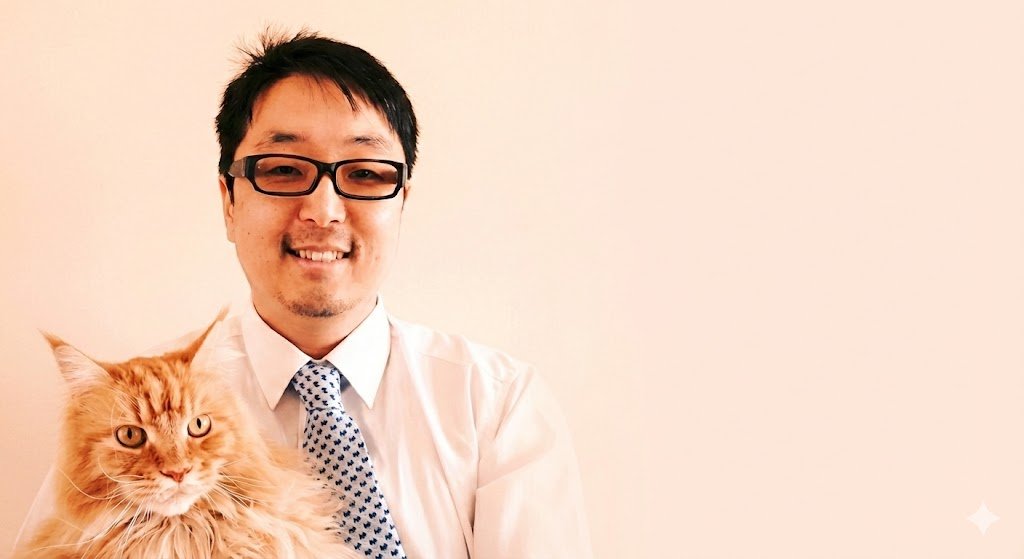 A vet with black hair, glasses, a white shirt, and animal pattern tie smiling, holding an orange tabby cat with long fur.