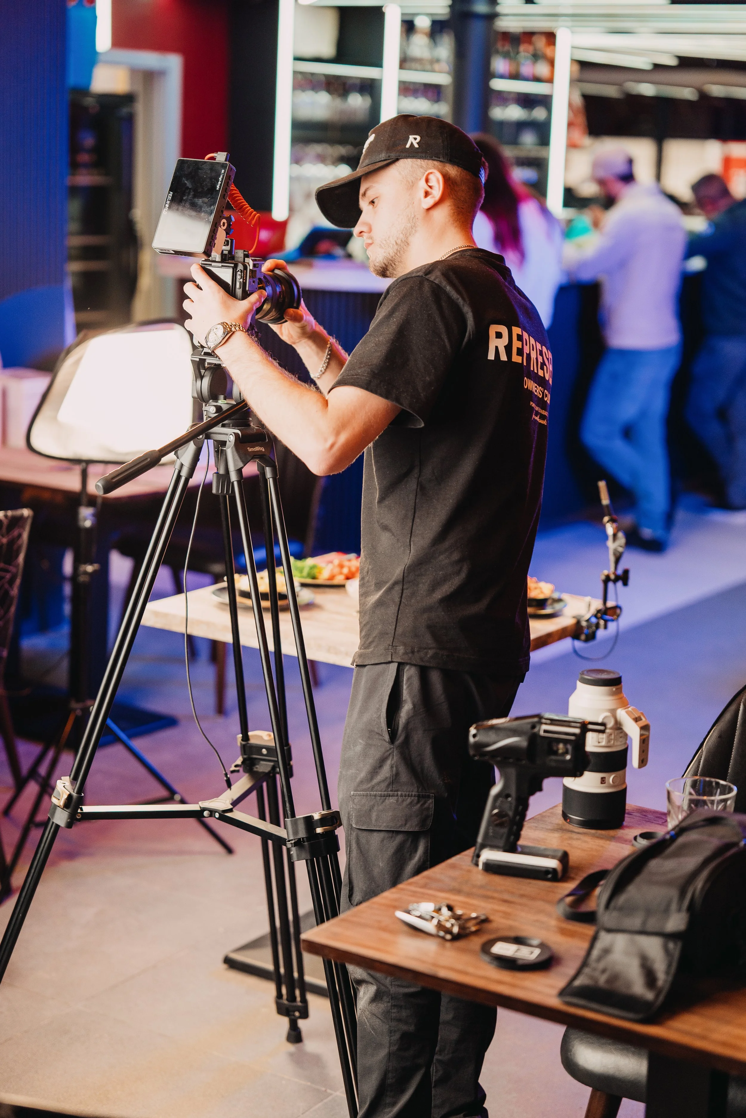A man using a Sony FX3 camera. Videographer / Cinematographer shooting food content for a restaurant / bar.