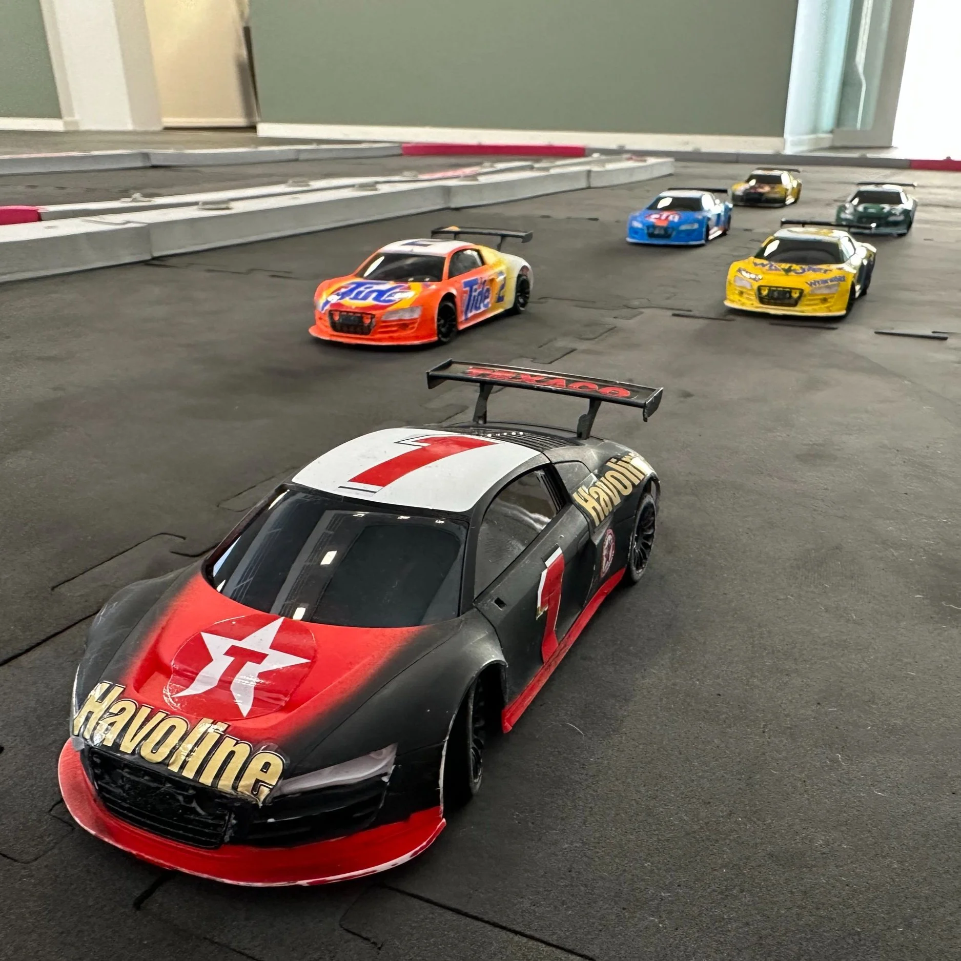 Tempofyldt teambuilding med fjernstyrede racerbiler på indendørs racerbane for kollegaer