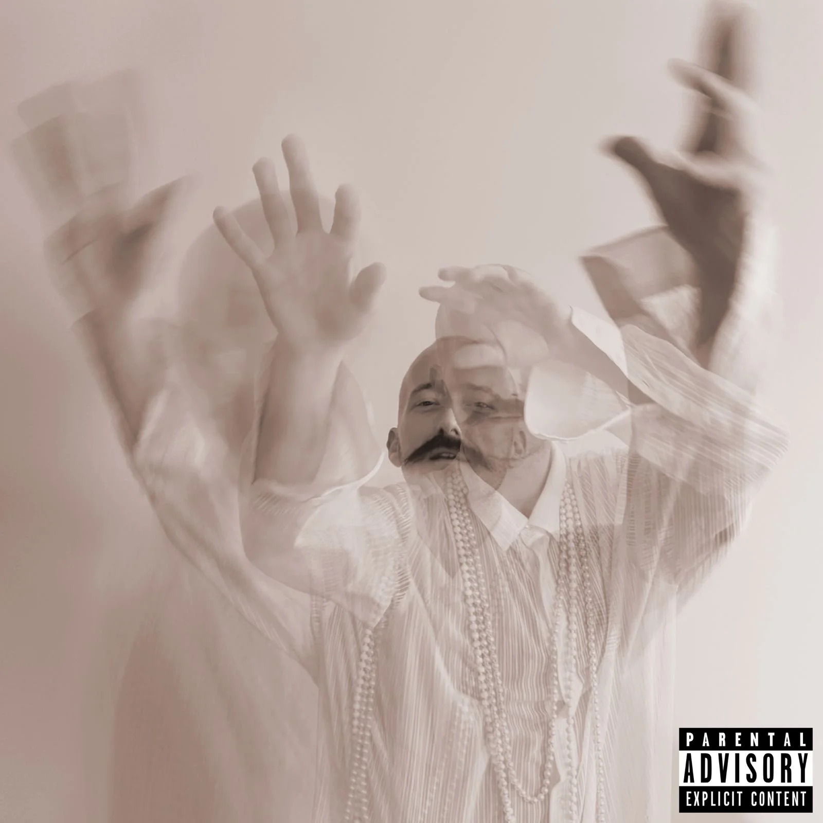 Blurred image of a man with a mustache and beads around his neck, raising his hand. The photo has multiple ghost-like overlays of the same man, creating a layered, abstract effect.