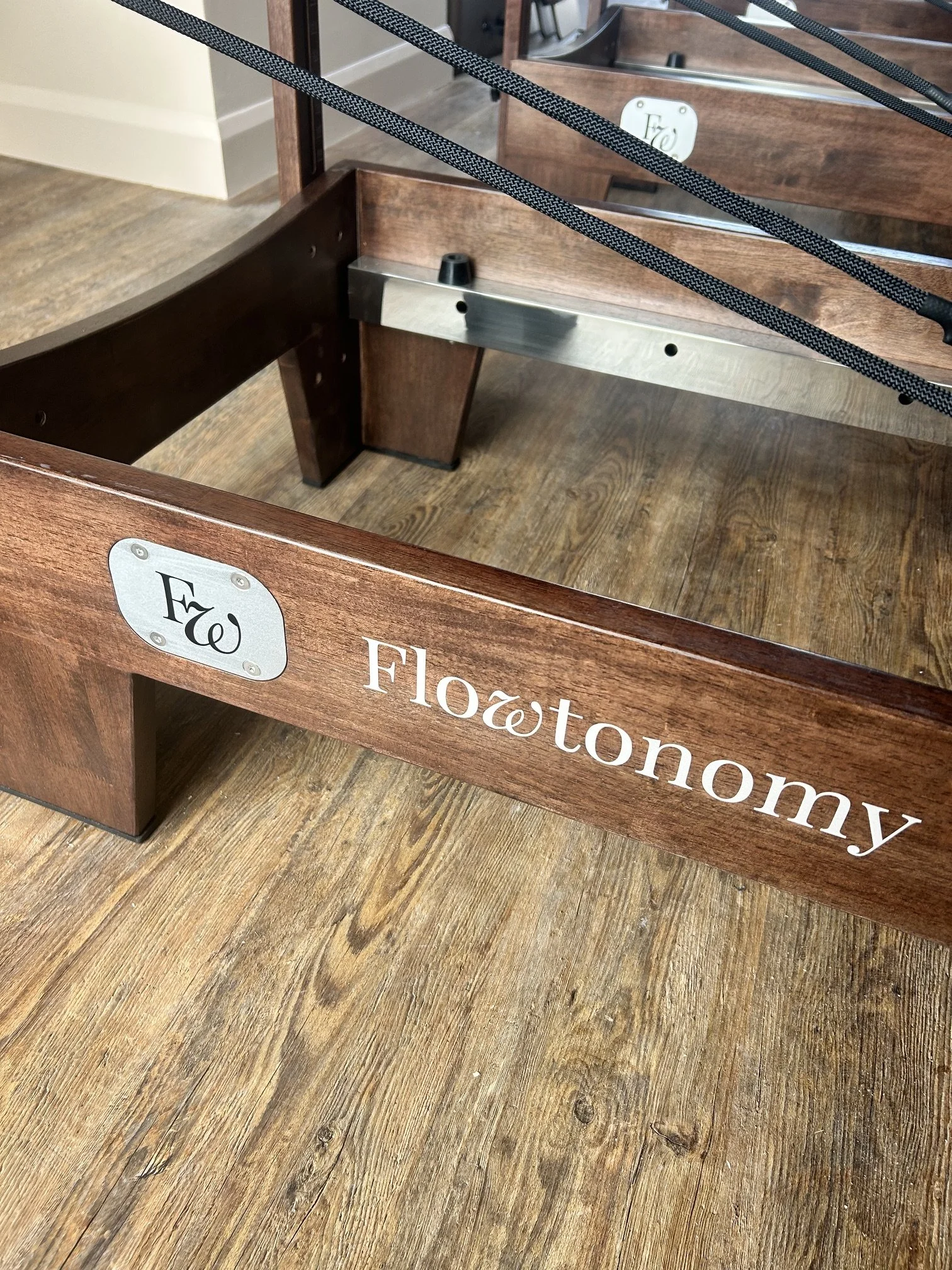 A wooden display stand with the words "Floatonomy" on the side and a metal support bar inside.