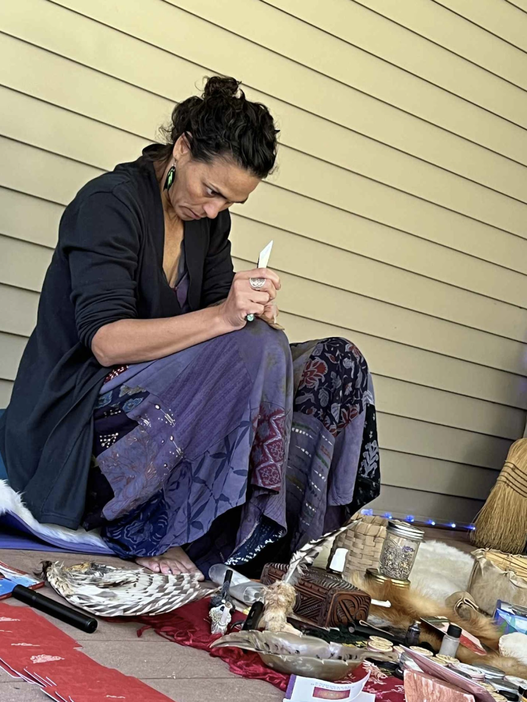 Heather Dexter seated with ceremonial tools, preparing Kambo for application.