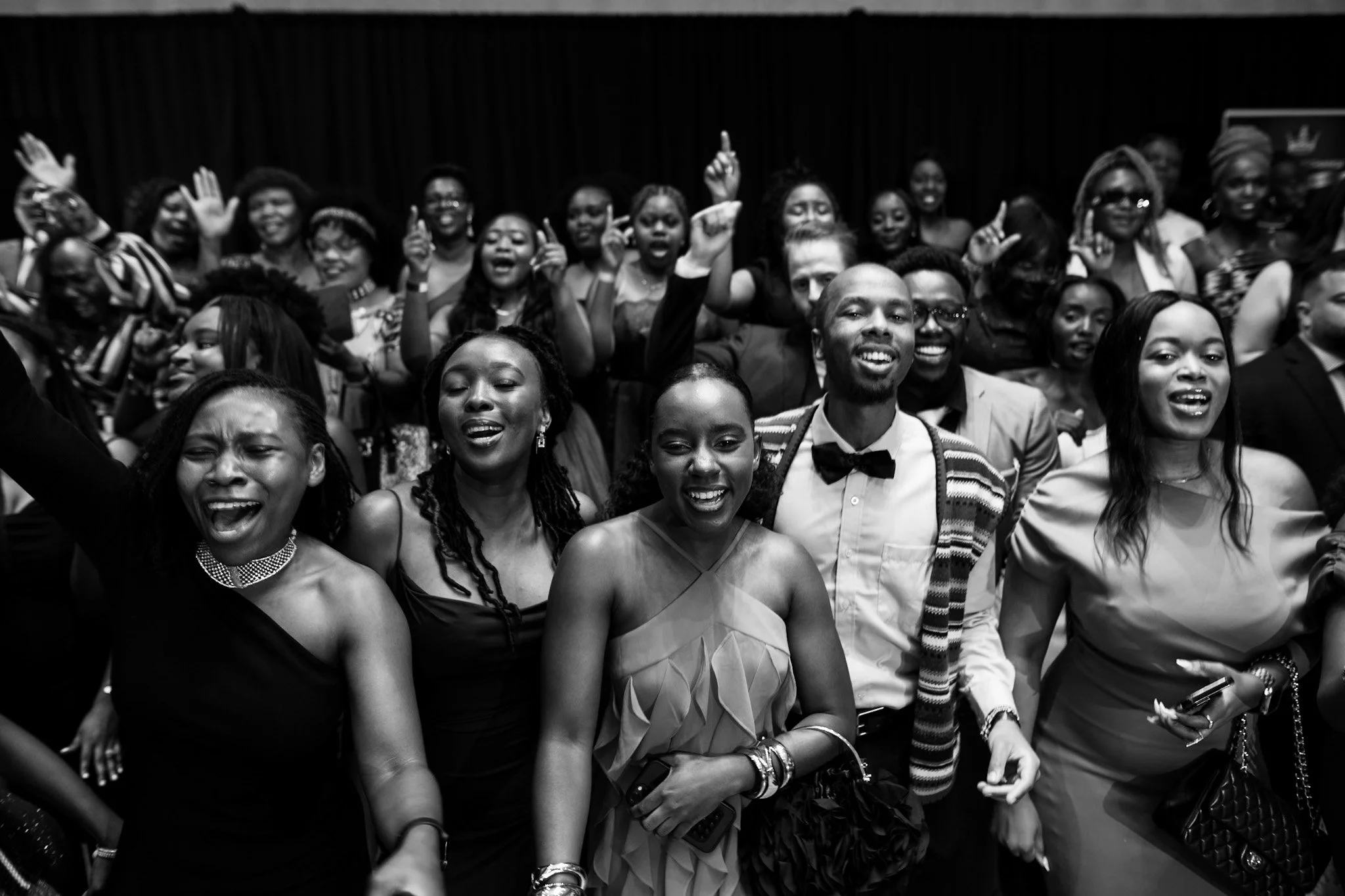 Group of people at a celebration or event, smiling, dancing, and enjoying themselves.