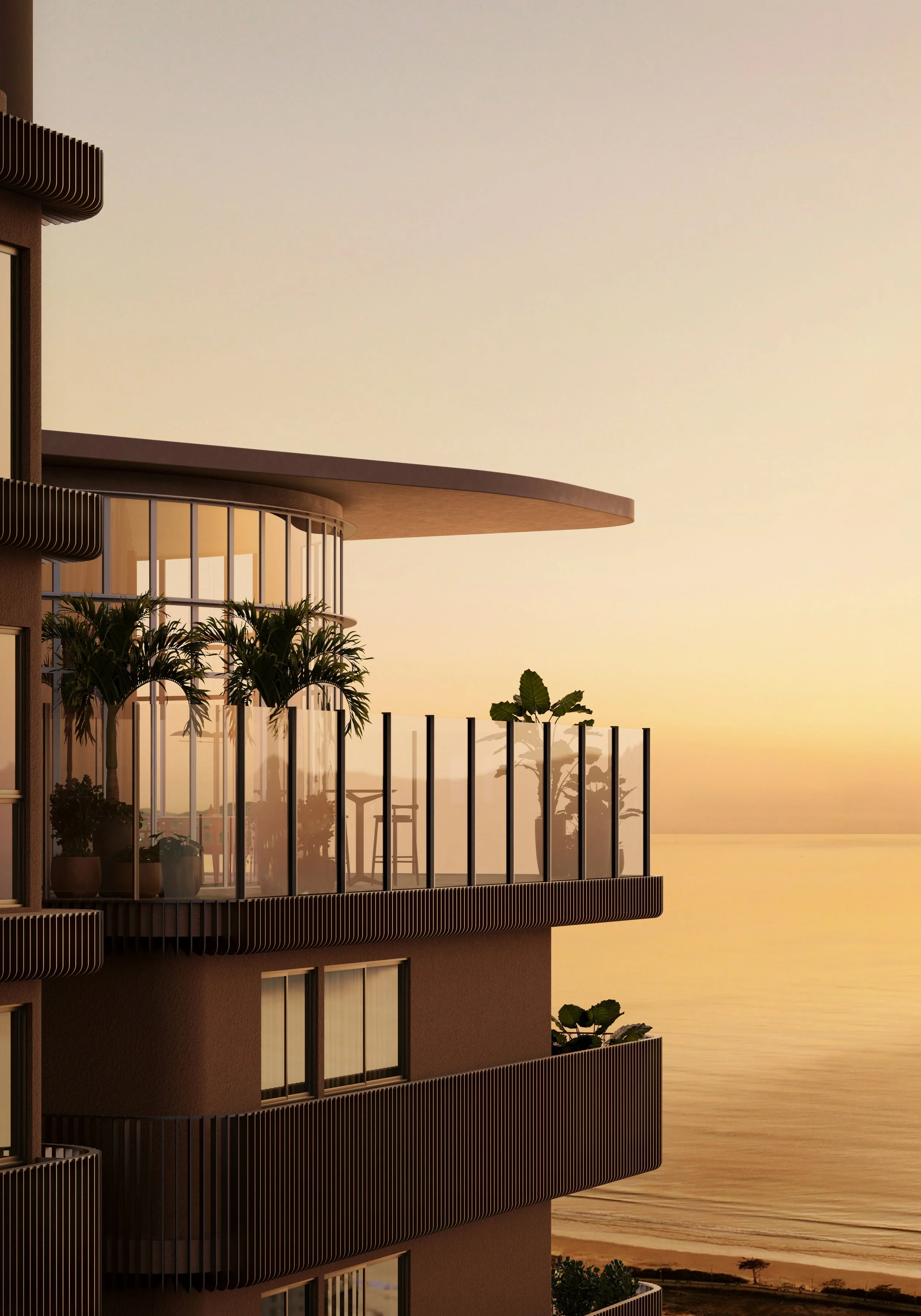 Prédio com varandas de vidro e plantas, vista para o mar ao pôr do sol.