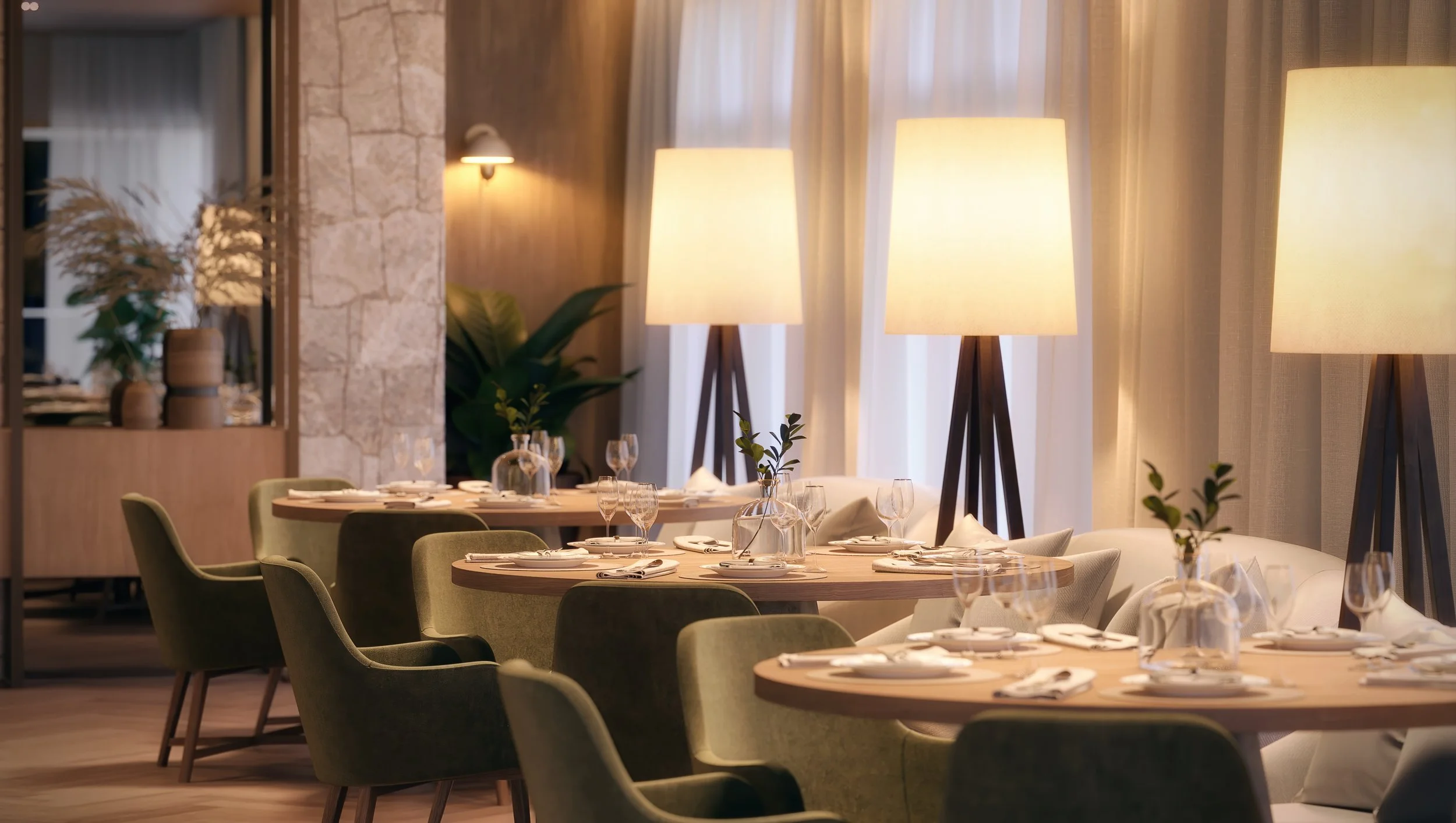 Salão de restaurante com mesas arrumadas com talheres e copos, cadeiras verdes, luminárias de pé e cortinas de tecido leve.