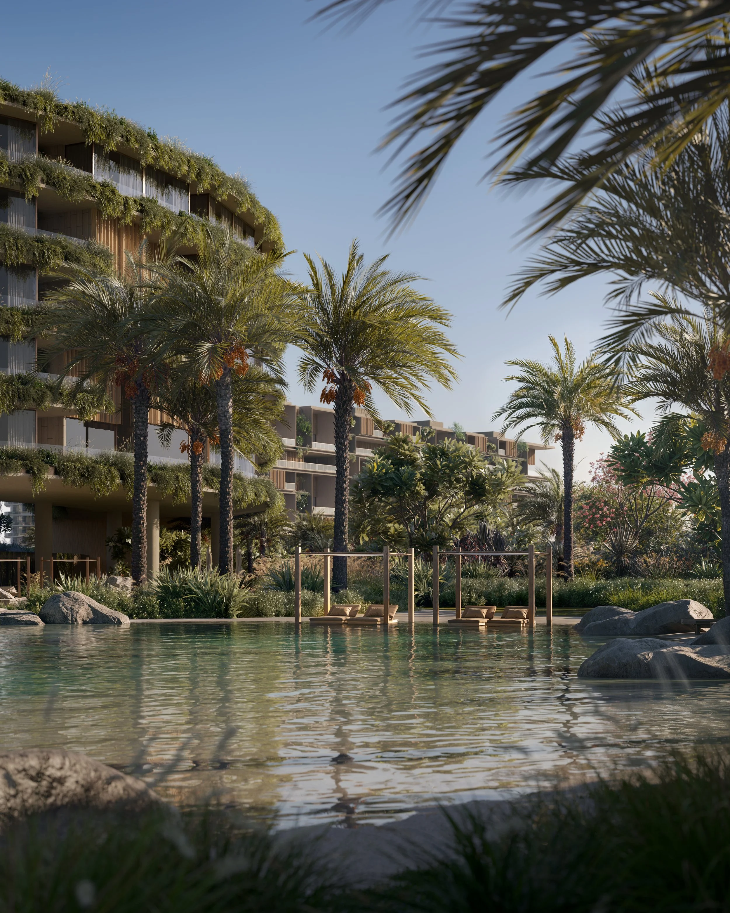 Piscina com espreguiçadeiras, cercada por palmeiras e vegetação tropical, no entorno de um edifício residencial moderno em Dubai, sob céu claro.