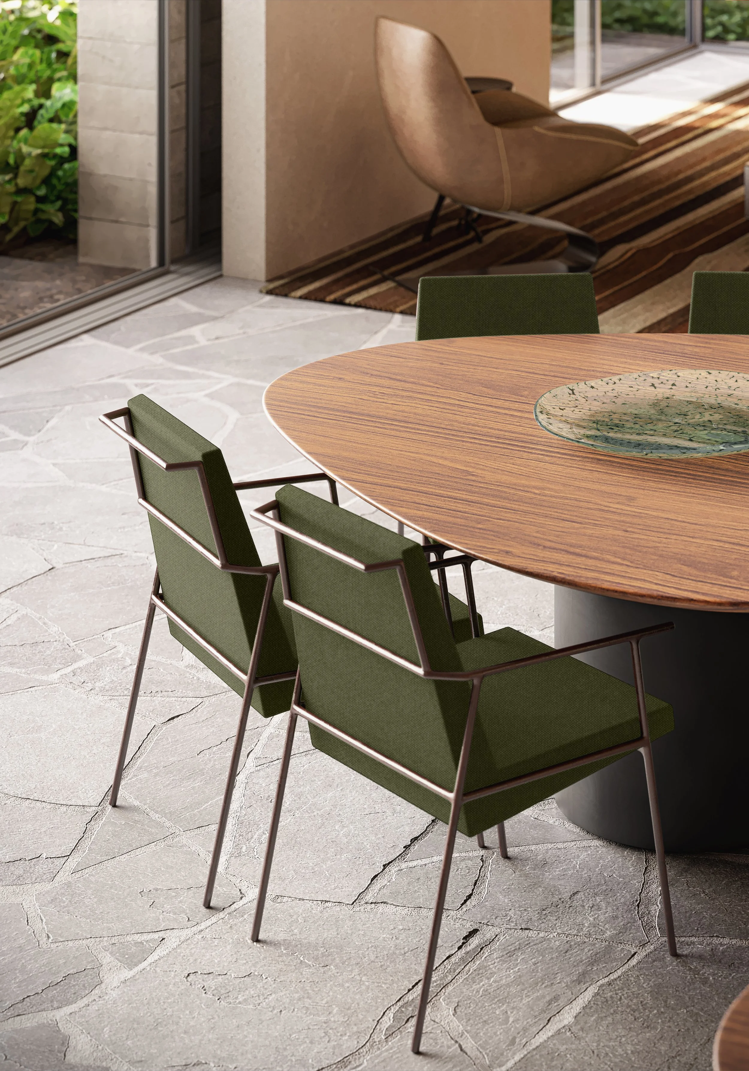 Sala de jantar com mesa de madeira oval e cinco cadeiras verdes de estrutura metálica, ao fundo há uma poltrona de couro e uma janela de vidro.