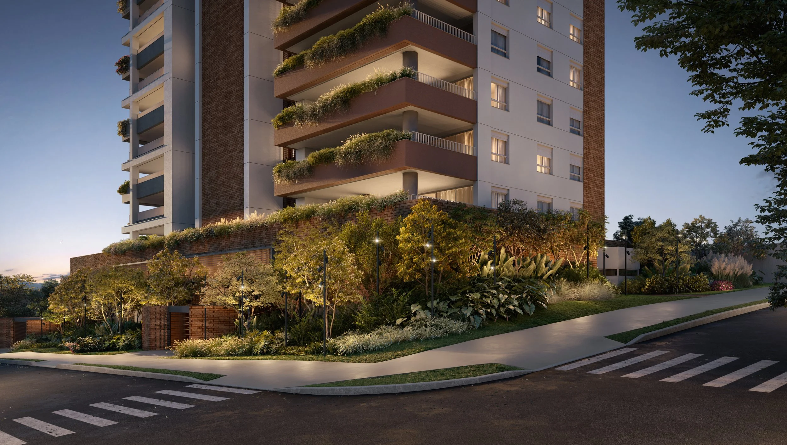 Prédio residencial em São Paulo com área de jardim bem iluminada na noite, com calçada, árvores e iluminação urbana ao redor.